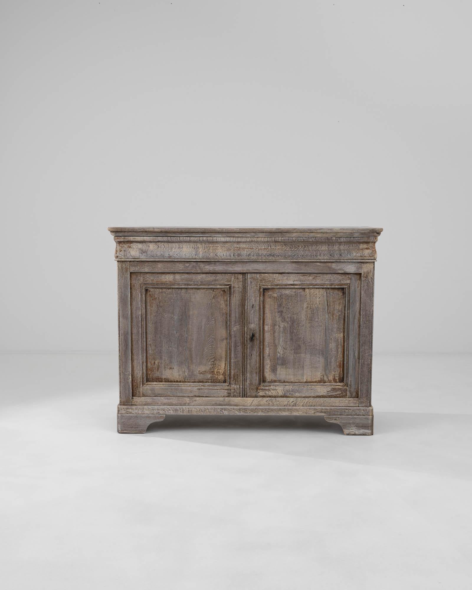 The impeccable geometry of this exquisite buffet is enhanced by the masterfully carved square panels on the doors, the sharply angled molded top, and the elegant ogee bracket feet that contribute to its refined profile. Crafted in France around
