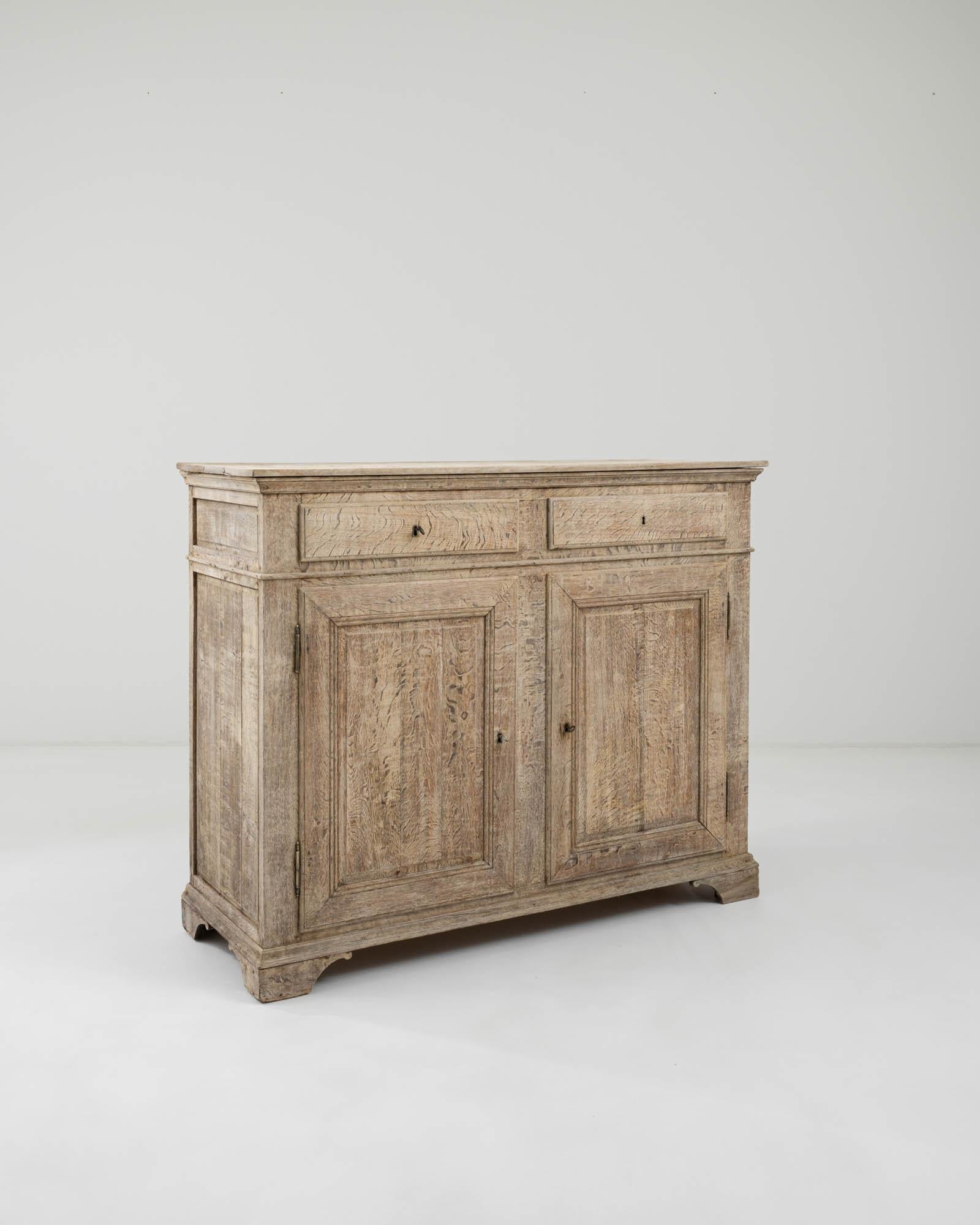 The quintessential Country French buffet cabinet, made circa 1900. The simple geometric shape recalls a countryside local and the time tested approach of regional French cabinet makers. Combining earthy colors and elevated craftsmanship, this buffet