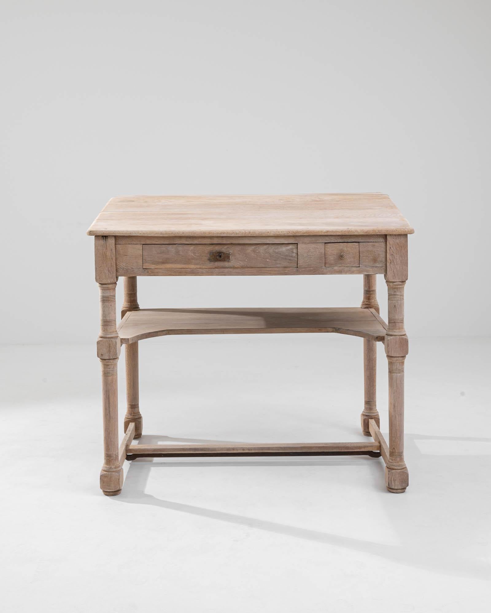 A wooden desk made in France, circa 1900. This desk is composed of a lower shelf, two drawers, and a sloped writing surface. The oak has been treated with a sensitive bleaching process which both protects the material and brings out the intricacies