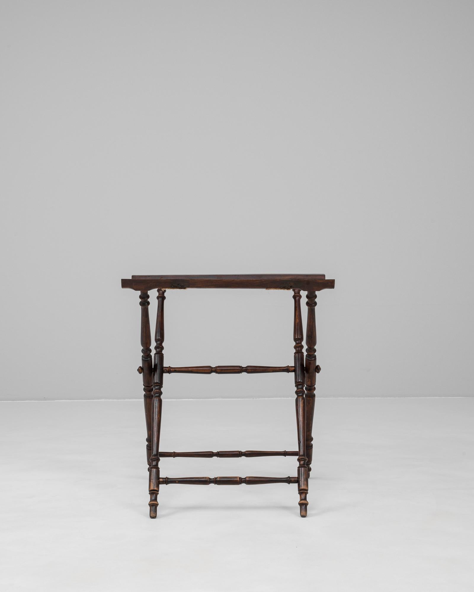 Ce plateau de maître d'hôtel français des années 1900 présente une élégante facture en bois tourné avec un cadre en X pliant classique. La finition en noyer foncé met en valeur la riche patine de la pièce et souligne la précision des détails tournés