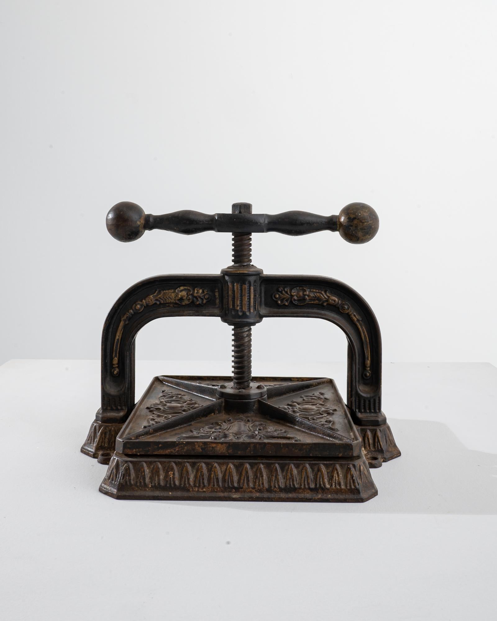 A cast iron press from 1900s France. Originally purposed as a book-binding press used in such places as banks or libraries, this unique antiquity suggests a niche function, while providing a universal visual appeal. Its cast iron form, speckled with