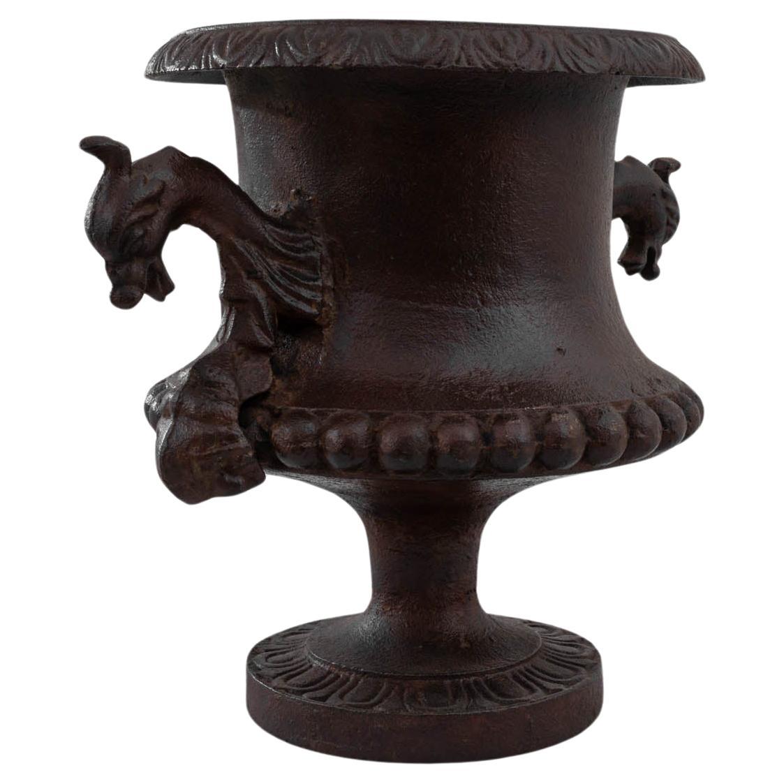 A cast iron planter from France, made in the 1900s. The campana shape resembled an upturned bell with a fluted cupola and broad lip, reminiscent of an opening blossom. Weathered over the years, the cast iron has acquired a striking layered patina: