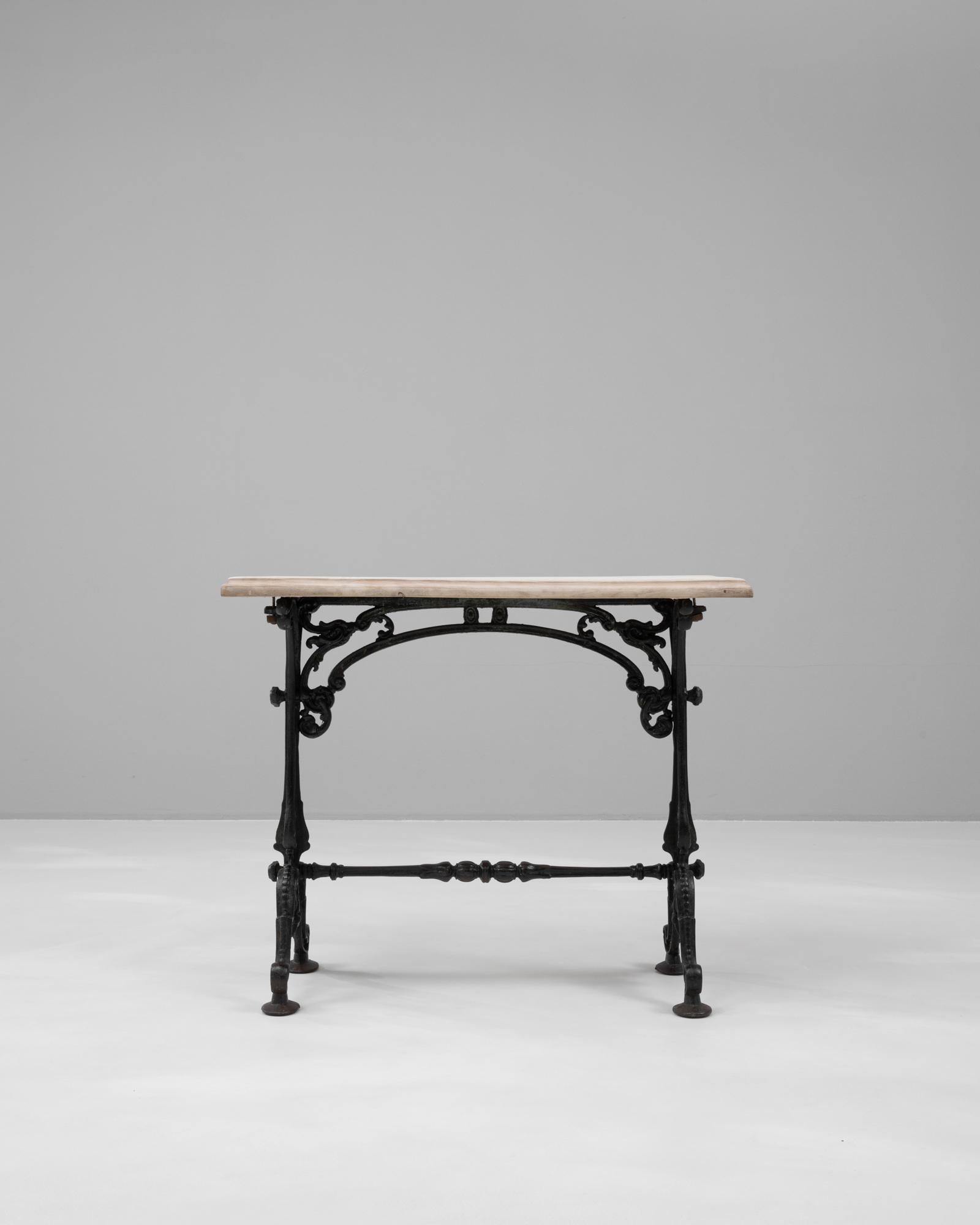 Cette table d'appoint en fonte française des années 1900 allie l'artisanat industriel à une élégance intemporelle. La base en fonte au design complexe présente des volutes ornées et une construction robuste, mettant en valeur les détails artistiques