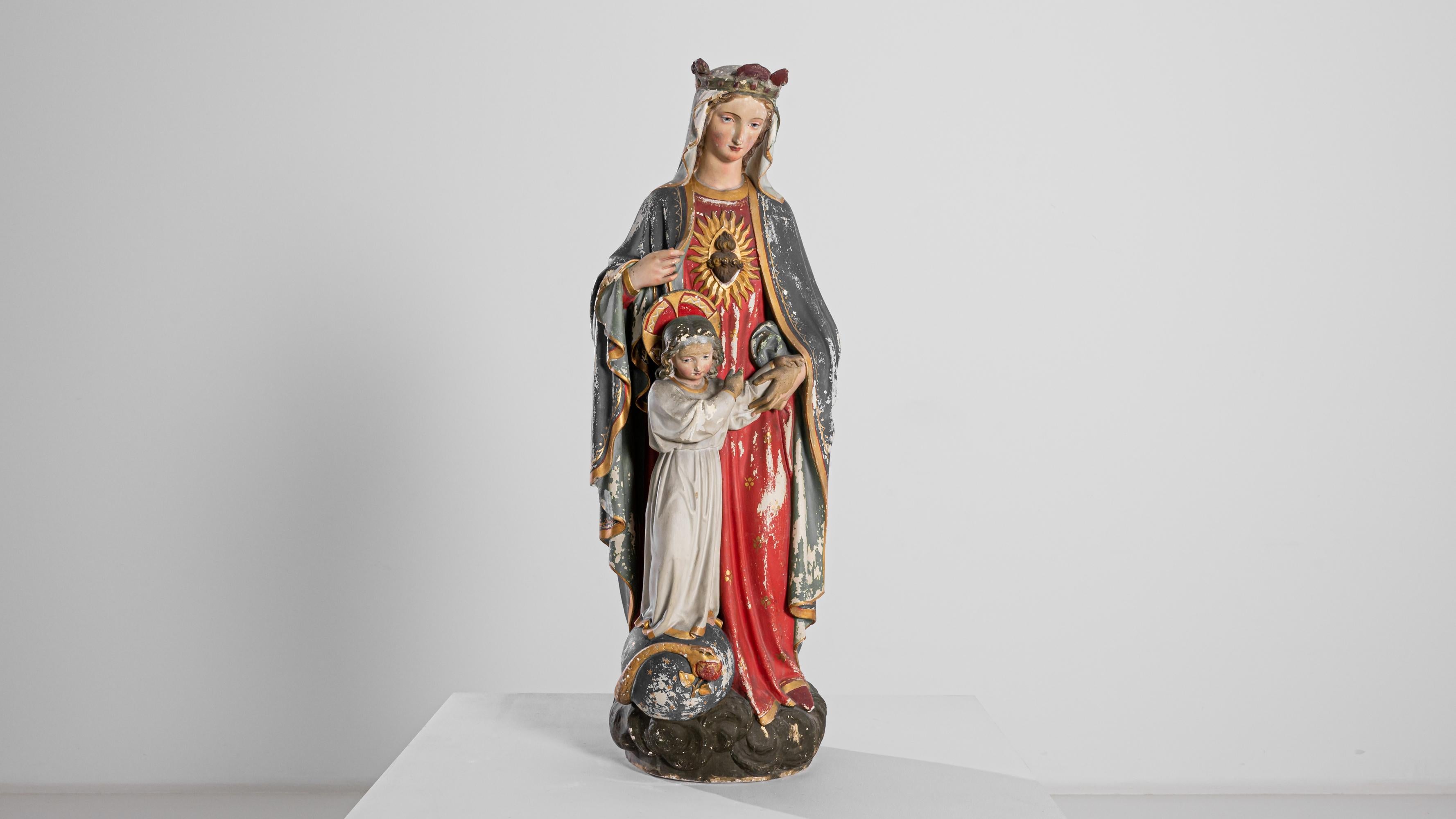 A ceramic liturgical sculpture from France, produced circa 1900. A three foot tall ceramic sculpture depicting the Virgin Mary standing alongside the Christ Child on a cosmos wrapped with a serpent holding the forbidden fruit in its mouth. A vibrant
