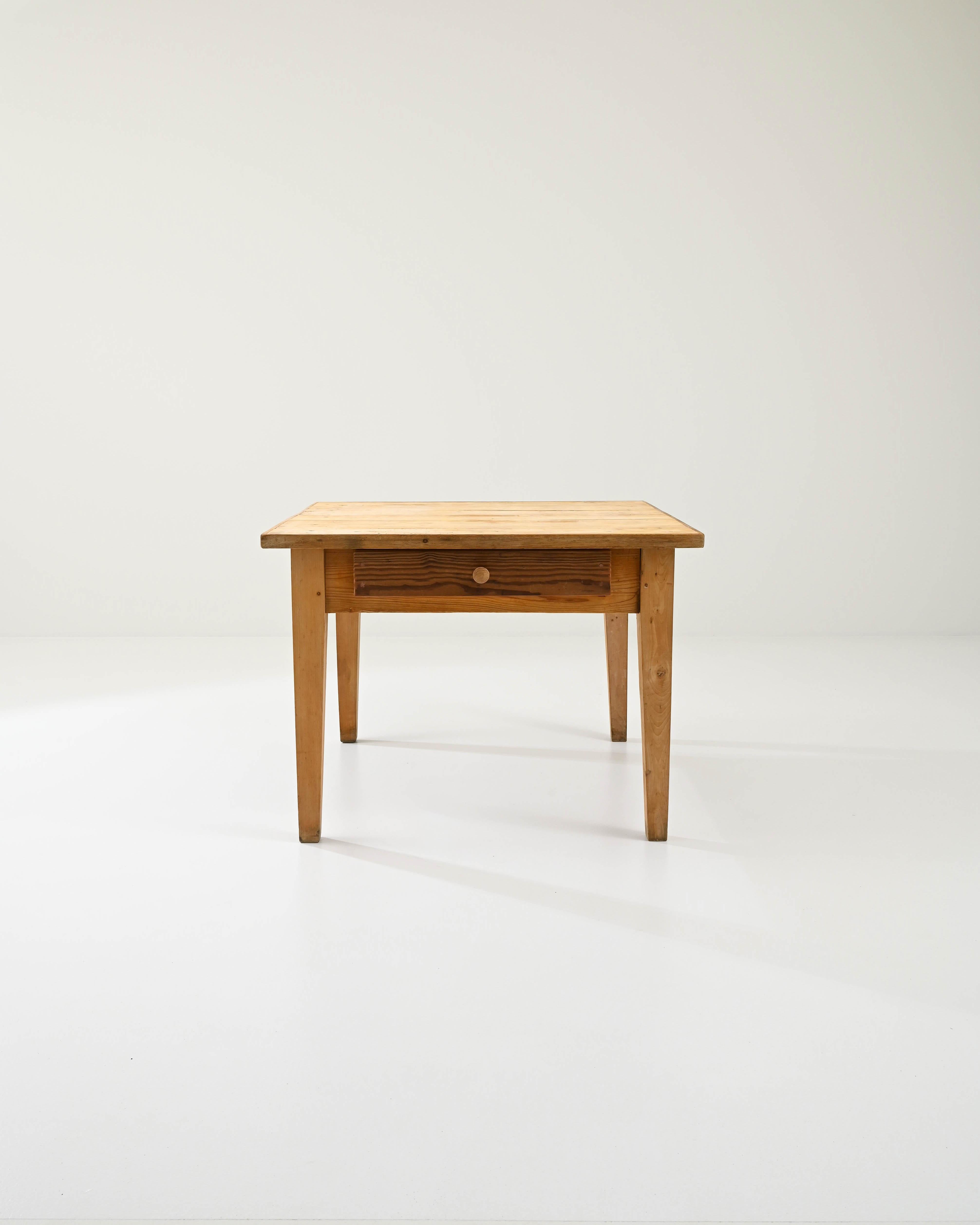 A wooden table created in 1900s France. Minimal and sturdily constructed, this table exudes a sense of forthright purpose and a cheery disposition. Mortise and tenon joinery, gently tapered legs, and a dowel peg construction, this table appears