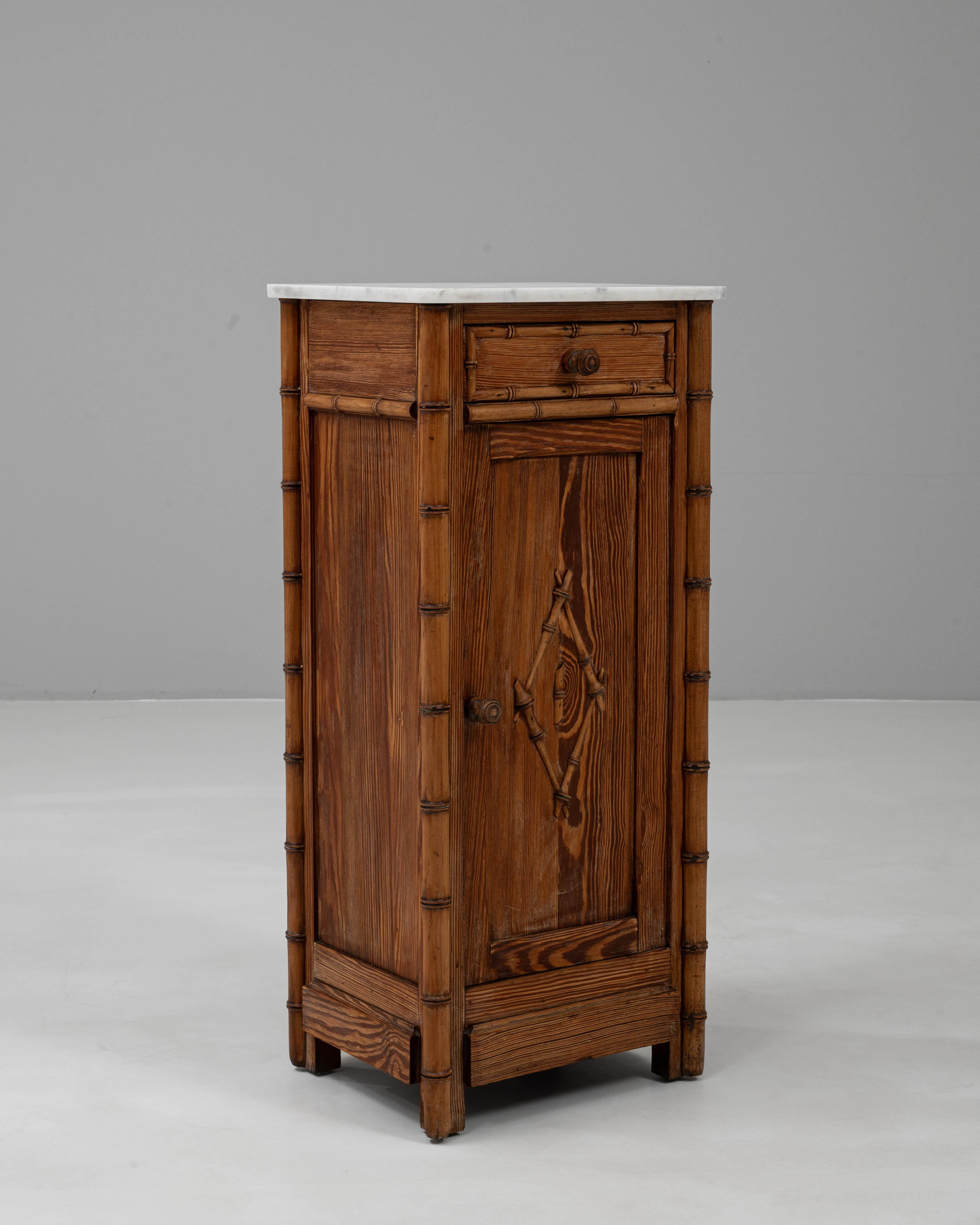 This 1900s French Faux Bamboo Bedside Table with Marble Top embodies the charm of late 19th to early 20th century craftsmanship. The frame is designed in a faux bamboo style, giving it an exotic yet refined appeal, while the warm wood patina