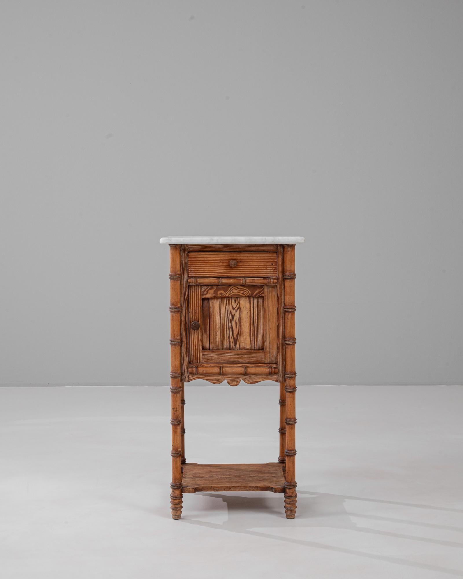 Esta mesilla de noche francesa de bambú sintético de 1900 presenta una encantadora artesanía típica de finales del siglo XIX y principios del XX. El armazón está construido con madera finamente tallada que imita el bambú, ofreciendo una estética