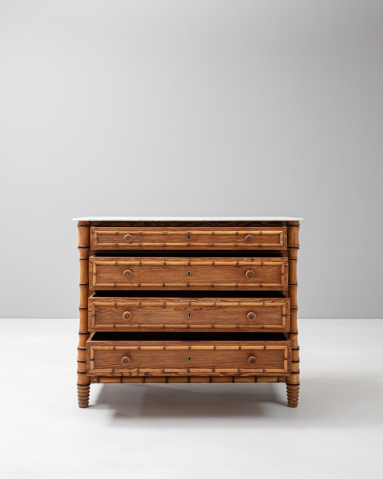 This exquisite 1900s French faux bamboo chest of drawers offers both functionality and classic French style. The chest is crafted to mimic the appearance of bamboo, lending it an elegant, tropical aesthetic. Its rich wood tones are complemented by
