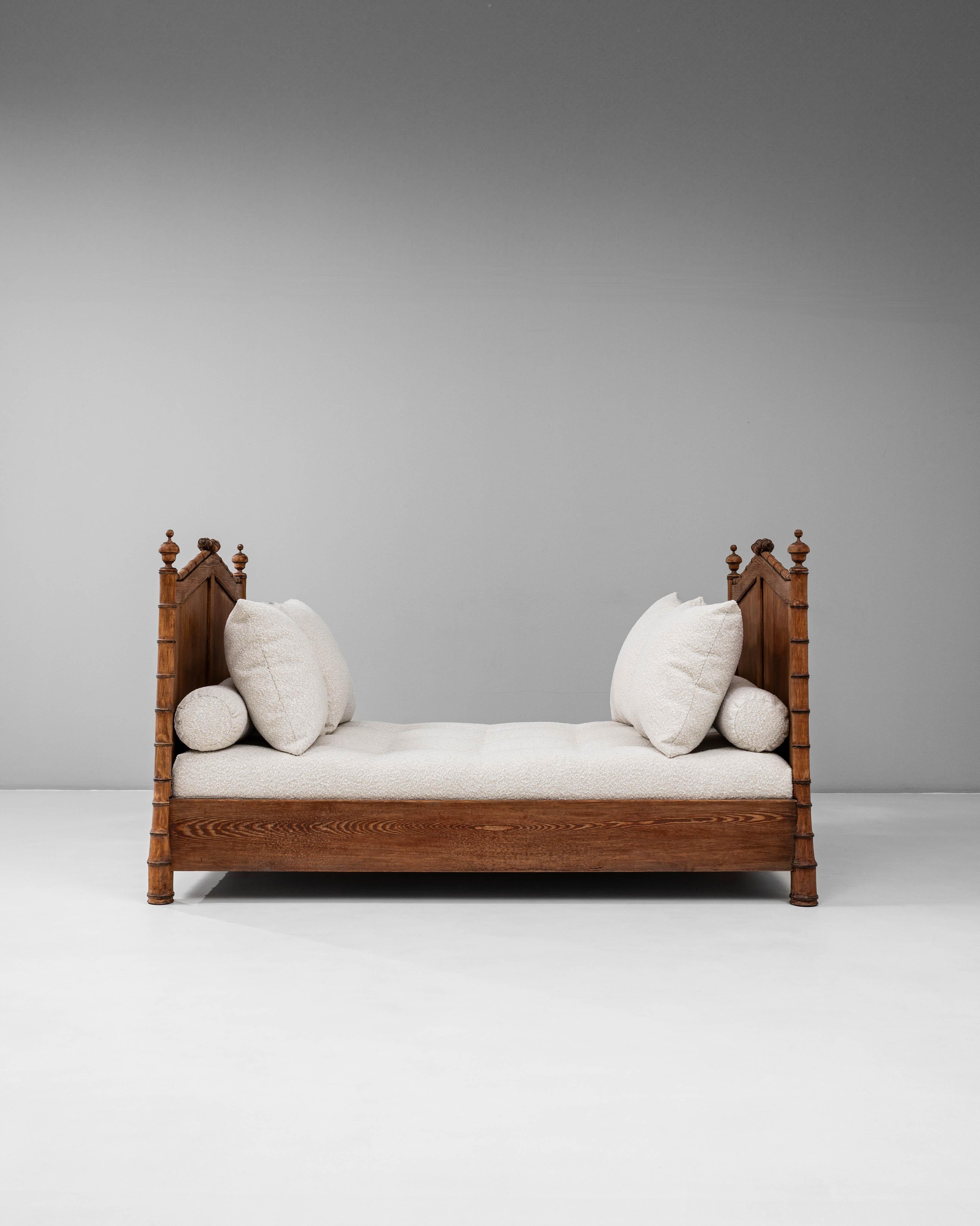 Ce lit de jour en faux bambou français des années 1900 avec coussins tapissés en bouclé capture le charme et l'artisanat du design français de la fin du 19e siècle au début du 20e siècle. Le cadre en bois massif, méticuleusement sculpté pour