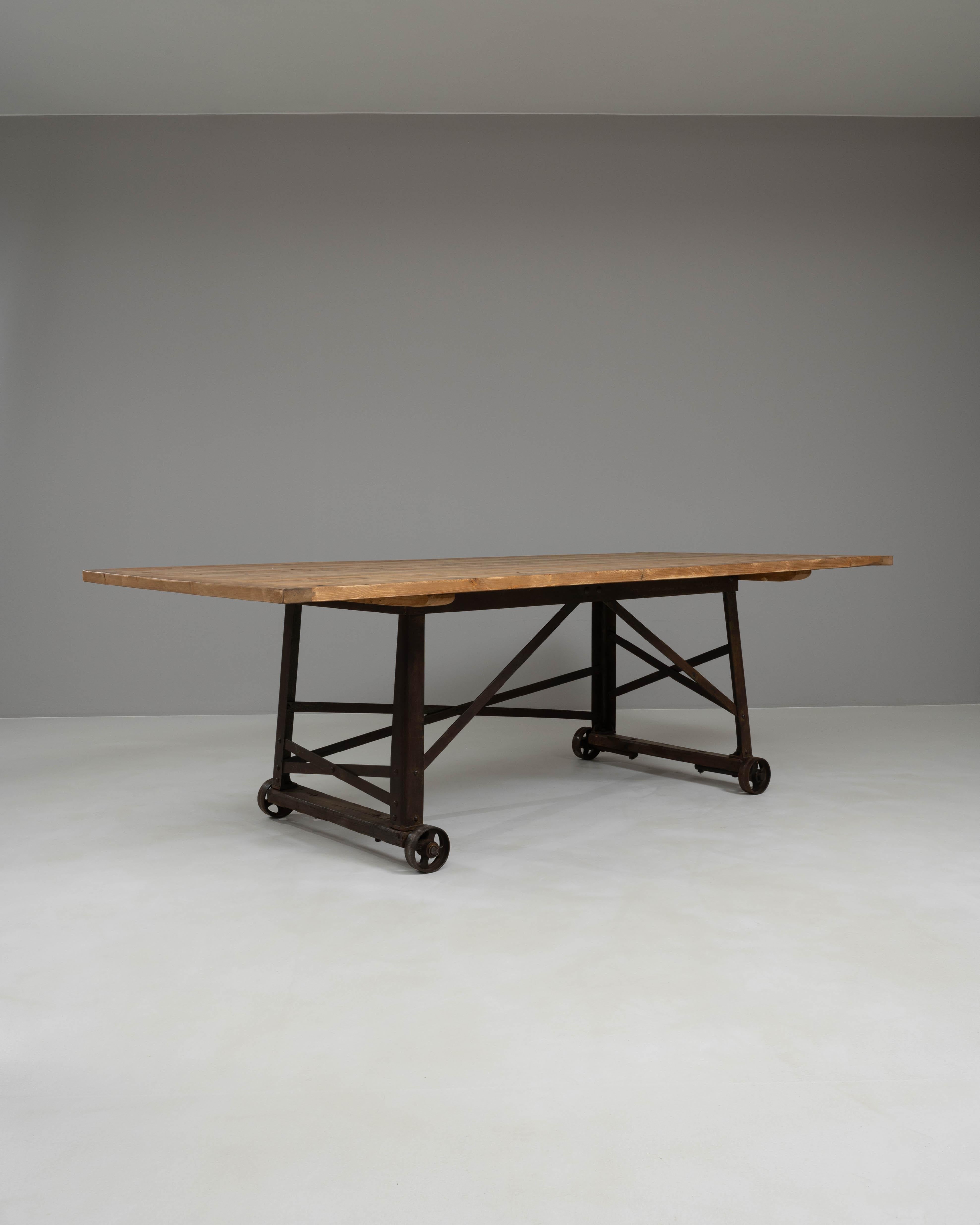 Questo tavolo industriale francese del 1900 incarna funzionalità e design senza tempo. Caratterizzato da un piano in legno massiccio con una patina ricca e calda, è sostenuto da una robusta base in ferro su ruote, che unisce la praticità a