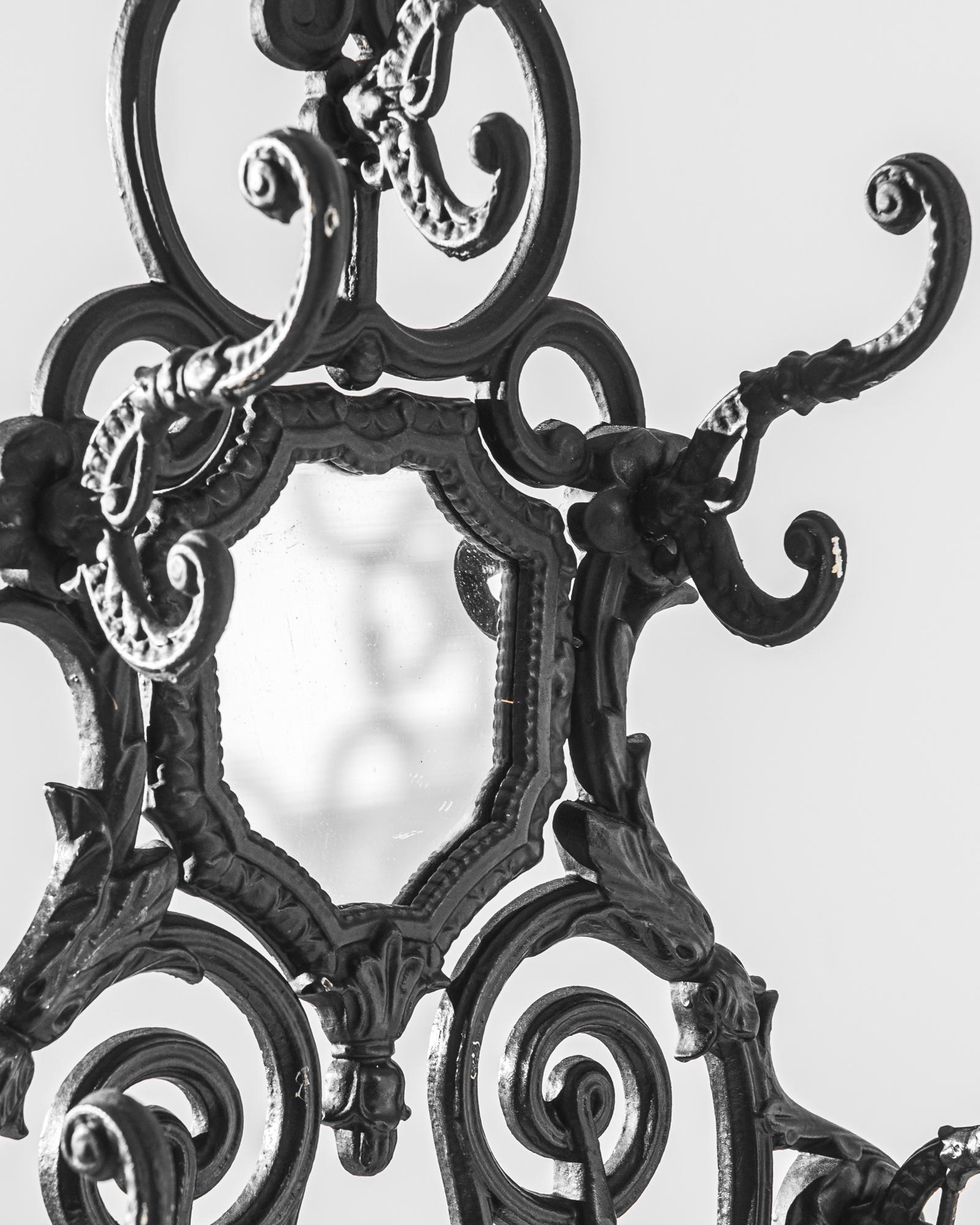Dieses exquisite französische Eisengestell aus der Zeit um 1900 ist ein Meisterwerk der Schmiedekunst, das mit seinen filigranen Schnörkeln und ornamentalen Details an die Eleganz der Belle Époque erinnert. Die dramatischen Konturen und Schnörkel
