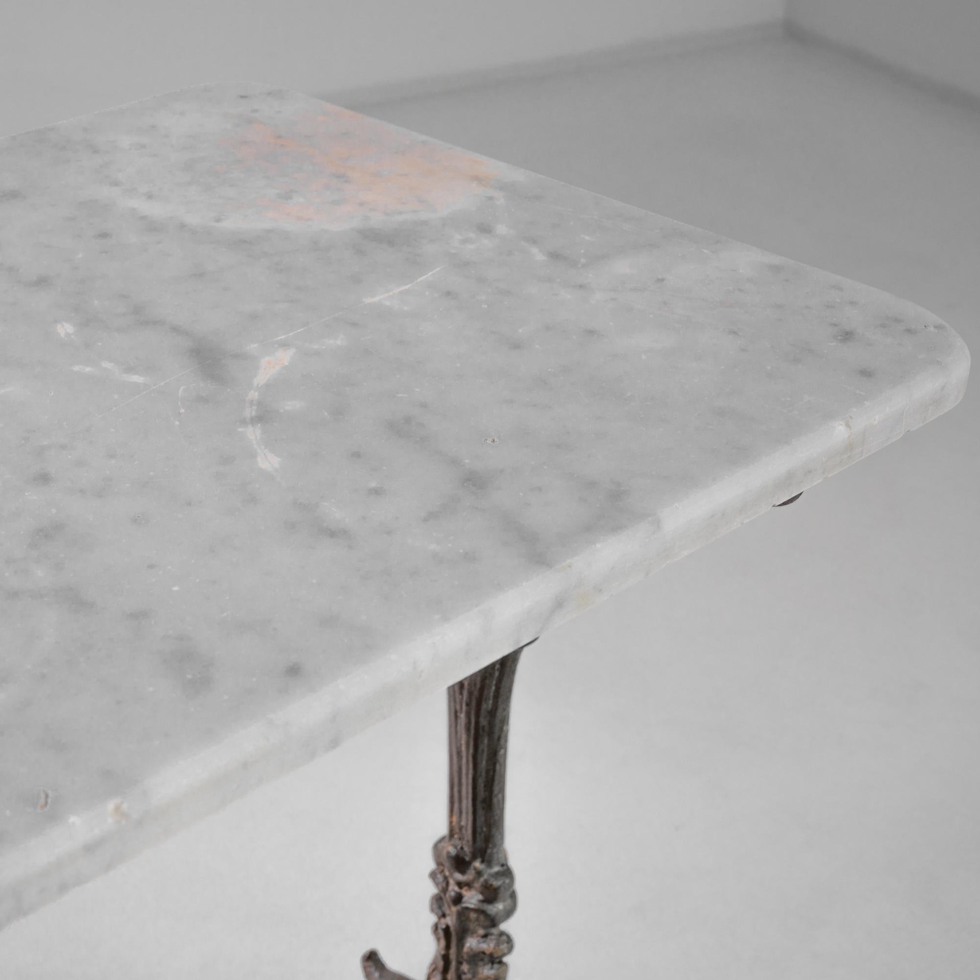 Entdecken Sie die Eleganz der Vergangenheit mit diesem französischen Eisentisch aus dem Jahr 1900, der einen meisterhaft gefertigten schmiedeeisernen Sockel mit verschnörkelten Schnörkeln aufweist. Das robuste Metallgestell, das für die