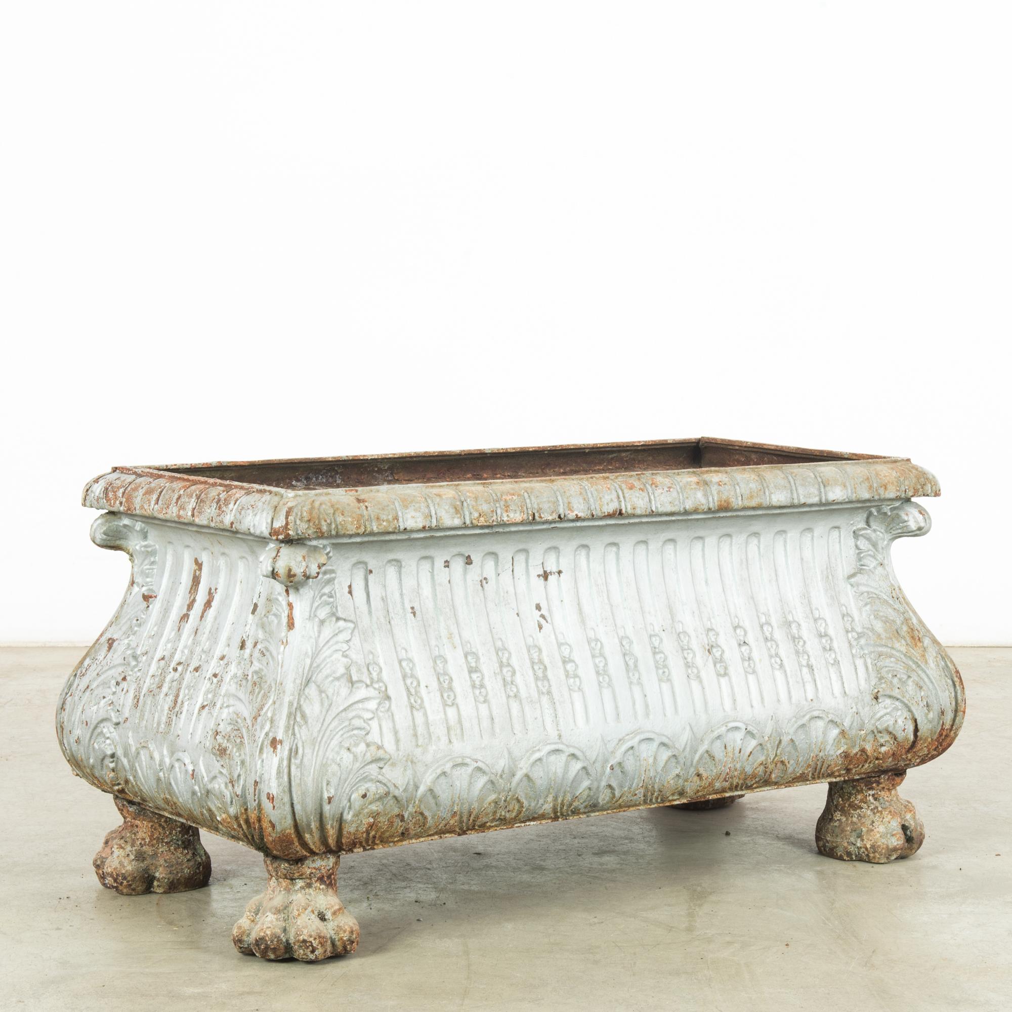 This 1900s French large metal planter exudes the quintessential charm of a bygone era. Its substantial size and robust construction are hallmarks of the period, designed to withstand the test of time. Adorned with classical motifs, the planter
