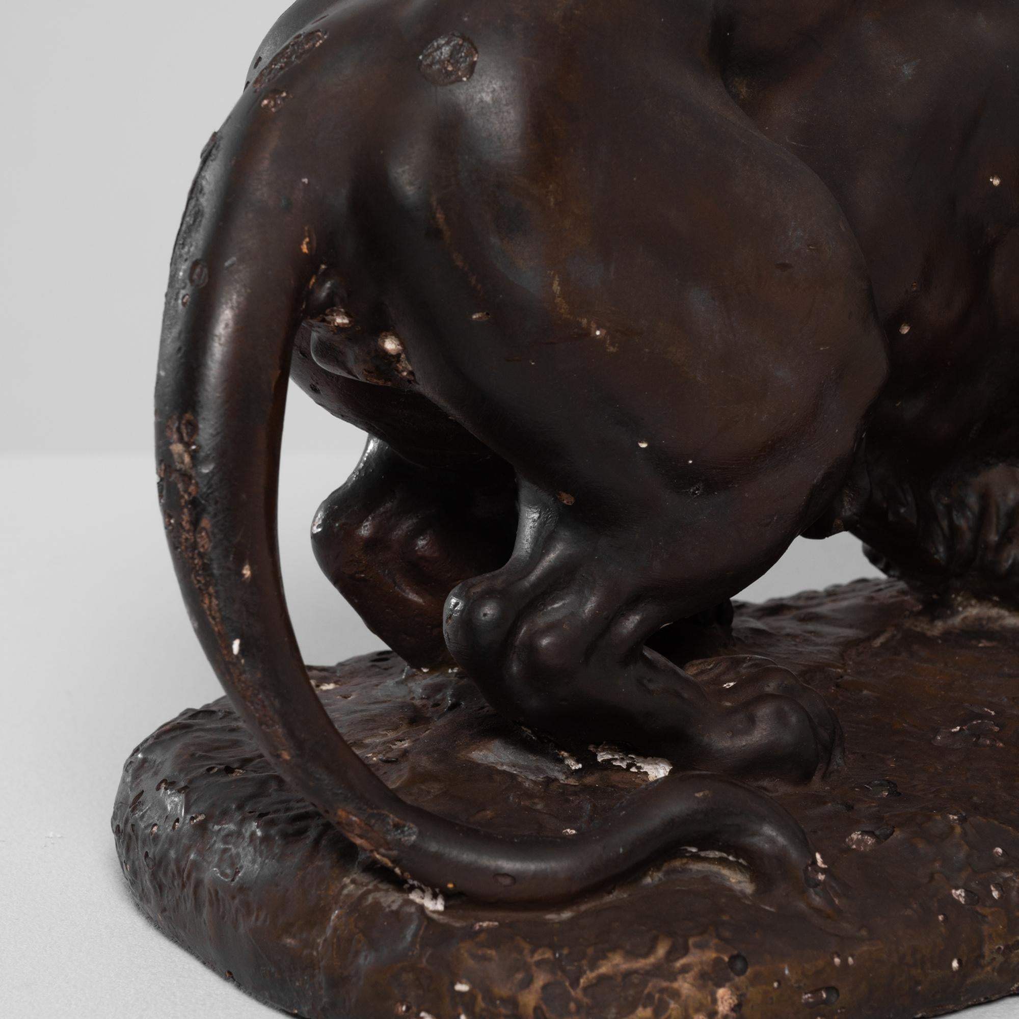 Capture the essence of majesty and strength with this Antique 1900s French Lion Plaster Sculpture. Standing in a dark finish, the sculpture portrays the regality and ferocity of a lion engaged in a battle. The intricate details bring the fierce