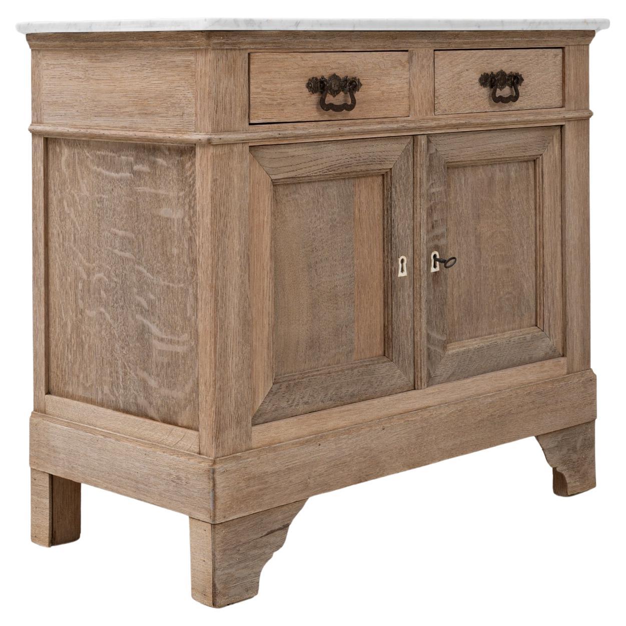 This 1900s French Louis Philippe buffet showcases the understated refinement of the period through its balanced proportions and timeless craftsmanship. Made from solid oak with a soft, natural patina, it features two drawers and paneled cabinet