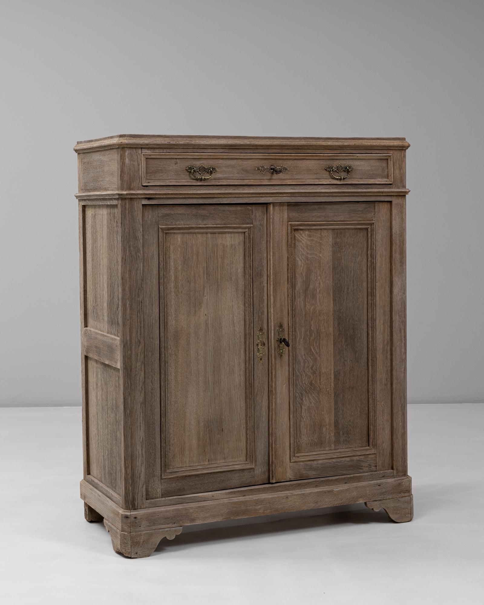 This 1900s French Louis Philippe style oak buffet showcases the refined simplicity and balanced form typical of the period. Crafted from solid oak with a softly patinated finish, it features a single top drawer with decorative brass pulls above two