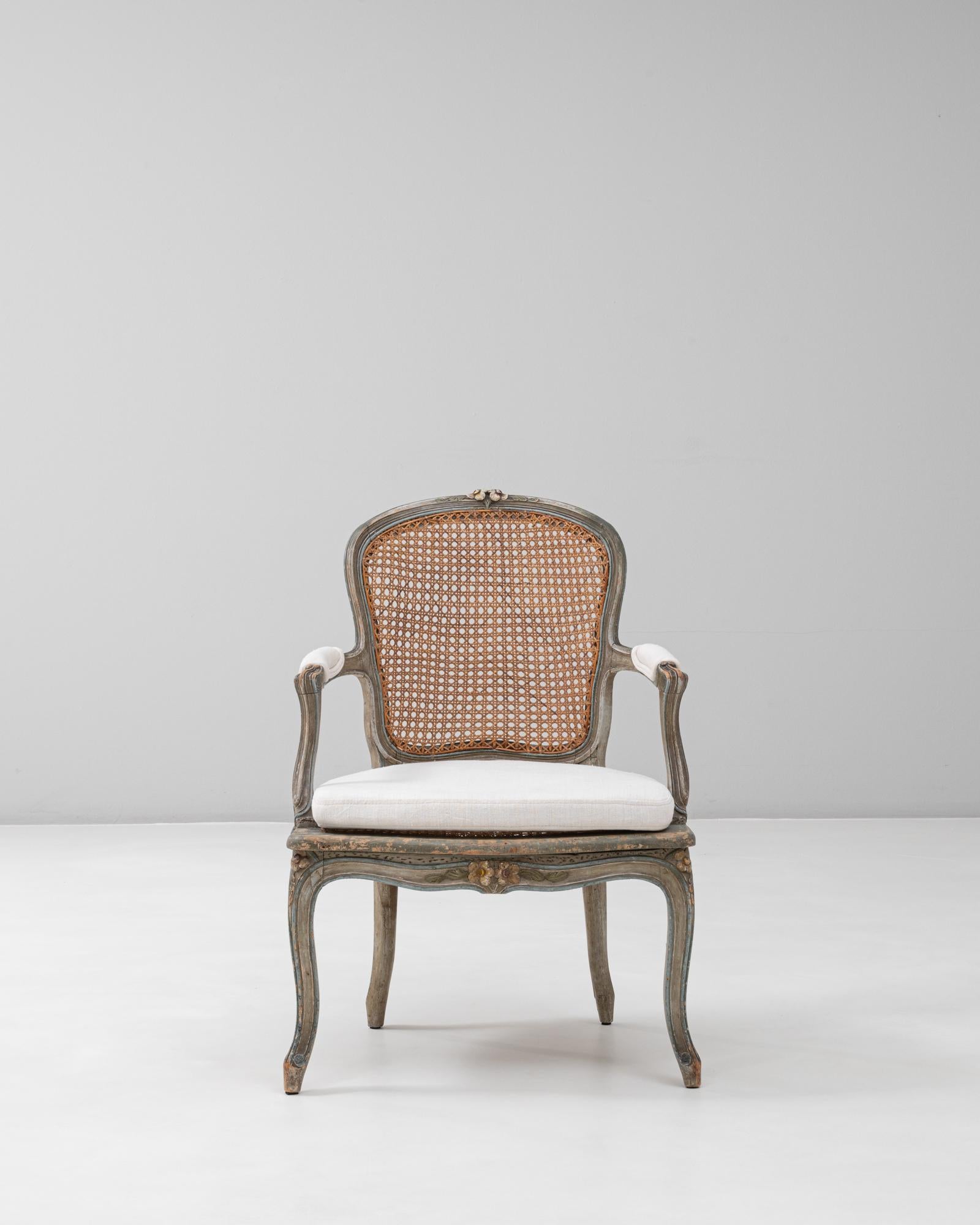 Este fauteuil de estilo Luis XV combina la elegancia del diseño francés del siglo XVIII con una funcionalidad atemporal. Con un armazón de madera tallada con graciosas patas cabriolé y delicados motivos florales, la silla ejemplifica las curvas