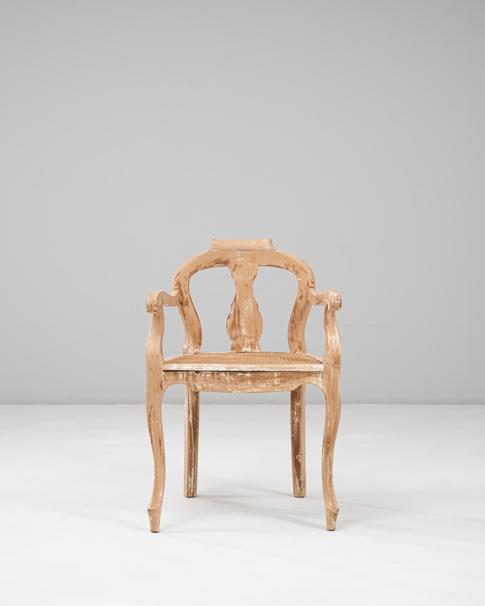 Ce fauteuil ouvert de style Louis XV français des années 1900 présente une silhouette élégante enrichie par sa finition patinée magnifiquement usée. Le dossier légèrement incurvé, les côtés ouverts et les accoudoirs en volute soulignent les lignes