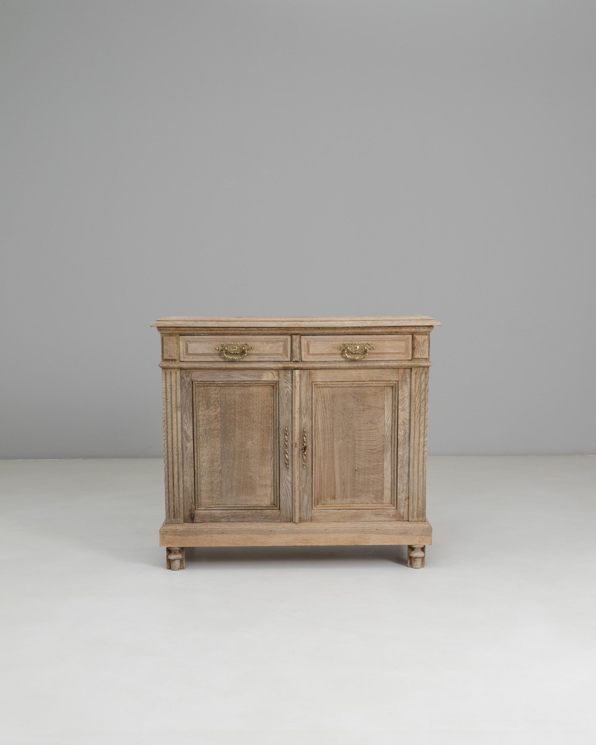 1900s French Louis XVI Oak Buffet. This early 20th-century buffet reflects the restrained elegance of the Louis XVI style, defined by clean lines, classical proportions, and subtle carved details. Crafted from solid oak with a softly weathered