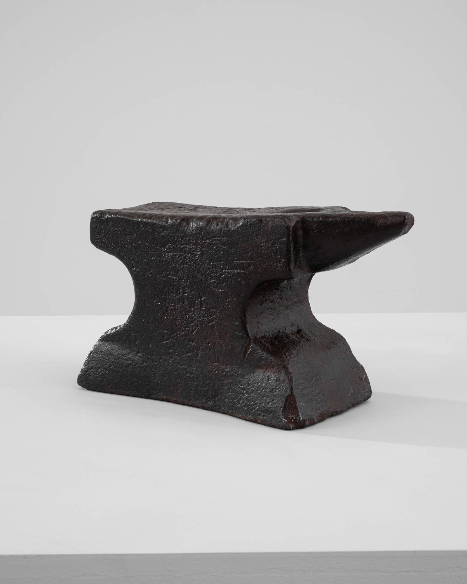 A metal anvil created in 1900s France. Weighty, battered, and time-worn, this solid chunk of history and craftsmanship radiates a palpable sense of a simpler, more hand-made time. Through the years, a delicate patina has spread across the surface of