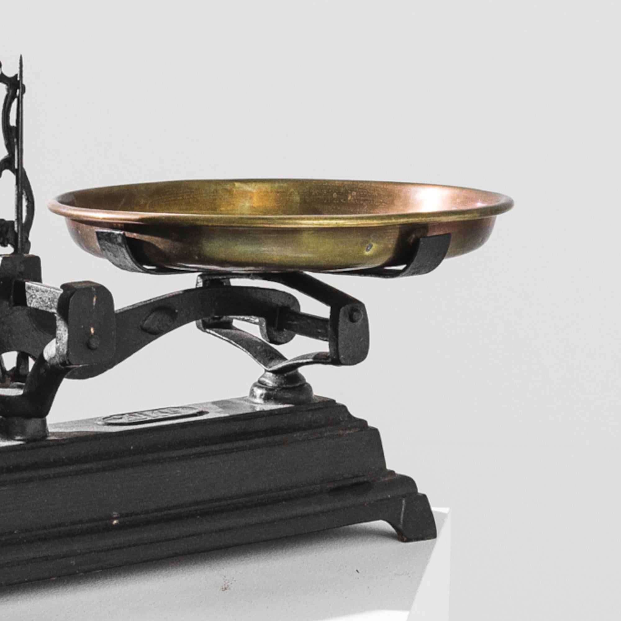 This vintage scale was produced in France, circa 1900. A household classic from the Roberval brand, this cast iron Force model can weigh up to 20kg. Fully functional, the scale is supplied with the original brass weighing pans, one of them shaped