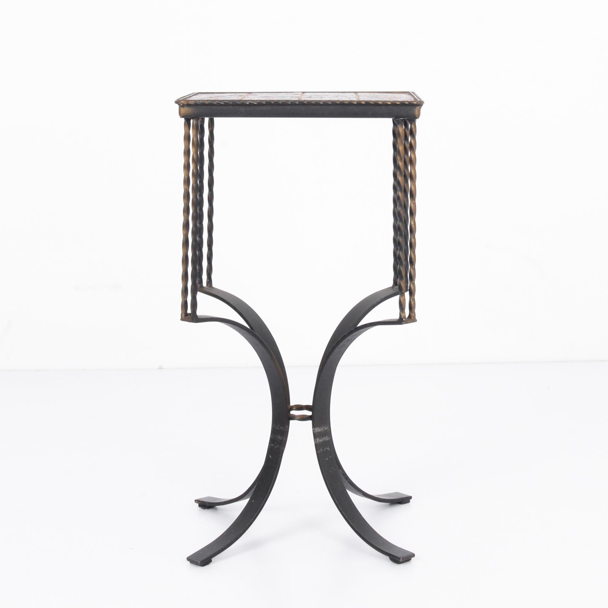 A small vintage metal side table with ceramic top produced in France, circa 1900. Delicate power play of springing torsion beginning in four flat planes of curved metal, each supporting spiraling twin spokes of a deconstructed double helix, all