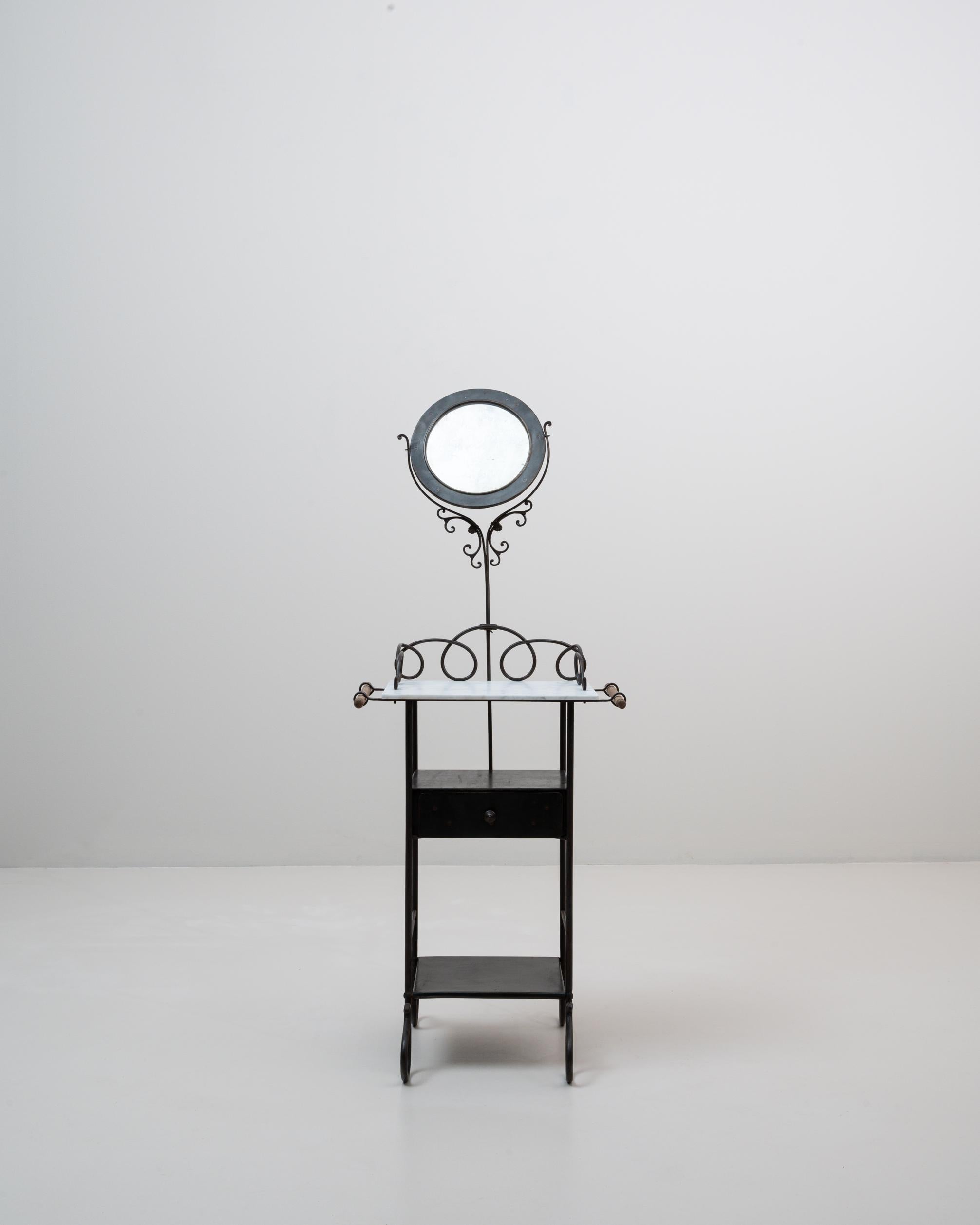 This 1900s French metal vanity combines delicate ironwork with functional elegance, showcasing the lightness and charm of early 20th-century design. The piece features a white marble top framed by gracefully looping metal scrolls, adding both