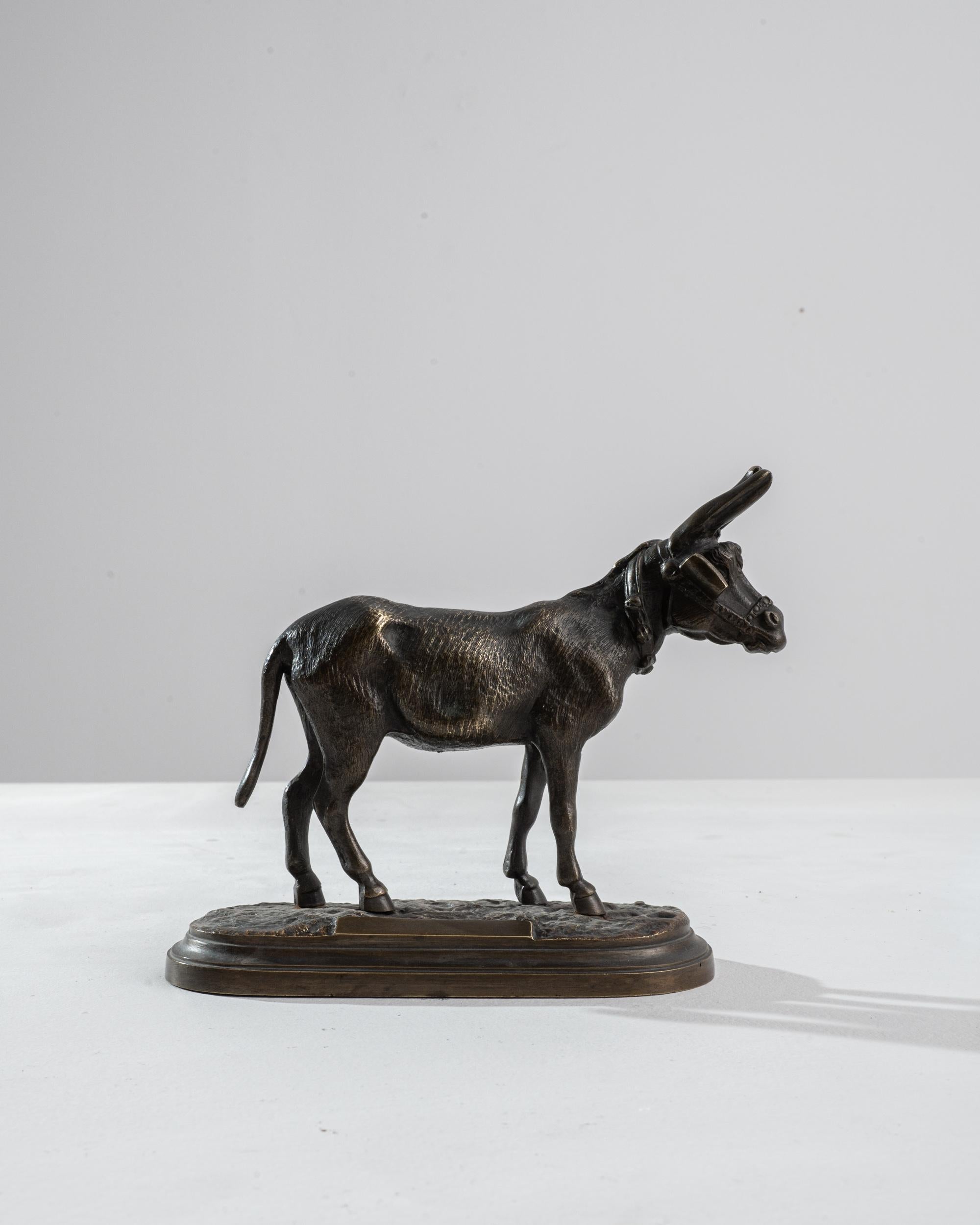 A 1900s French metal miniature statue. This small statue was first created in clay or wax and then completed by pouring bronze to create the final cast. Standing about five and a half inches, this neatly composed sculpture of a donkey conveys an