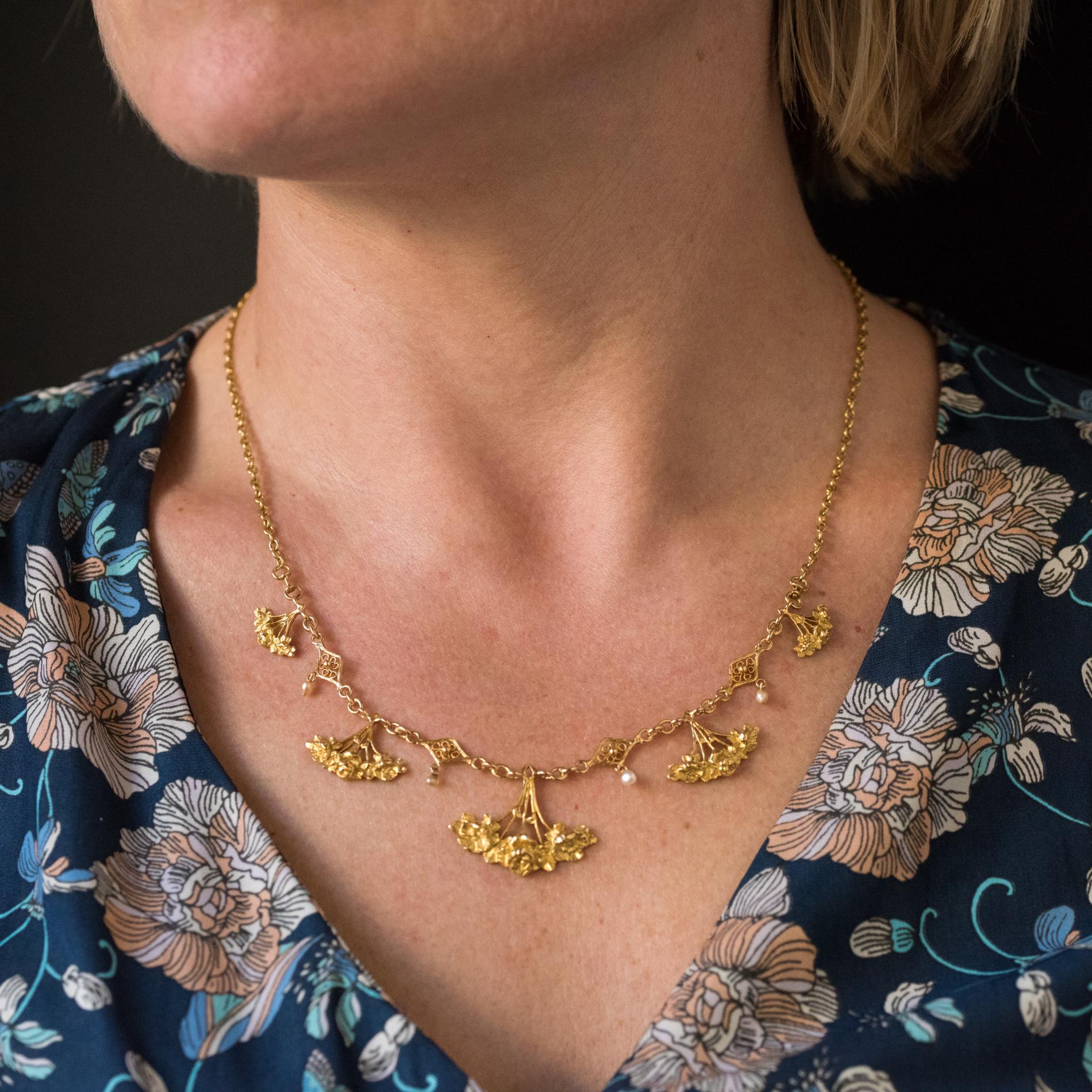 Necklace in 18 karats yellow gold, mixed hallmark.
Delightful drapery, this antique necklace is made of an oval convict mesh chain which holds on the front 5 falling patterns representing bouquets of engraved roses separated from each other by