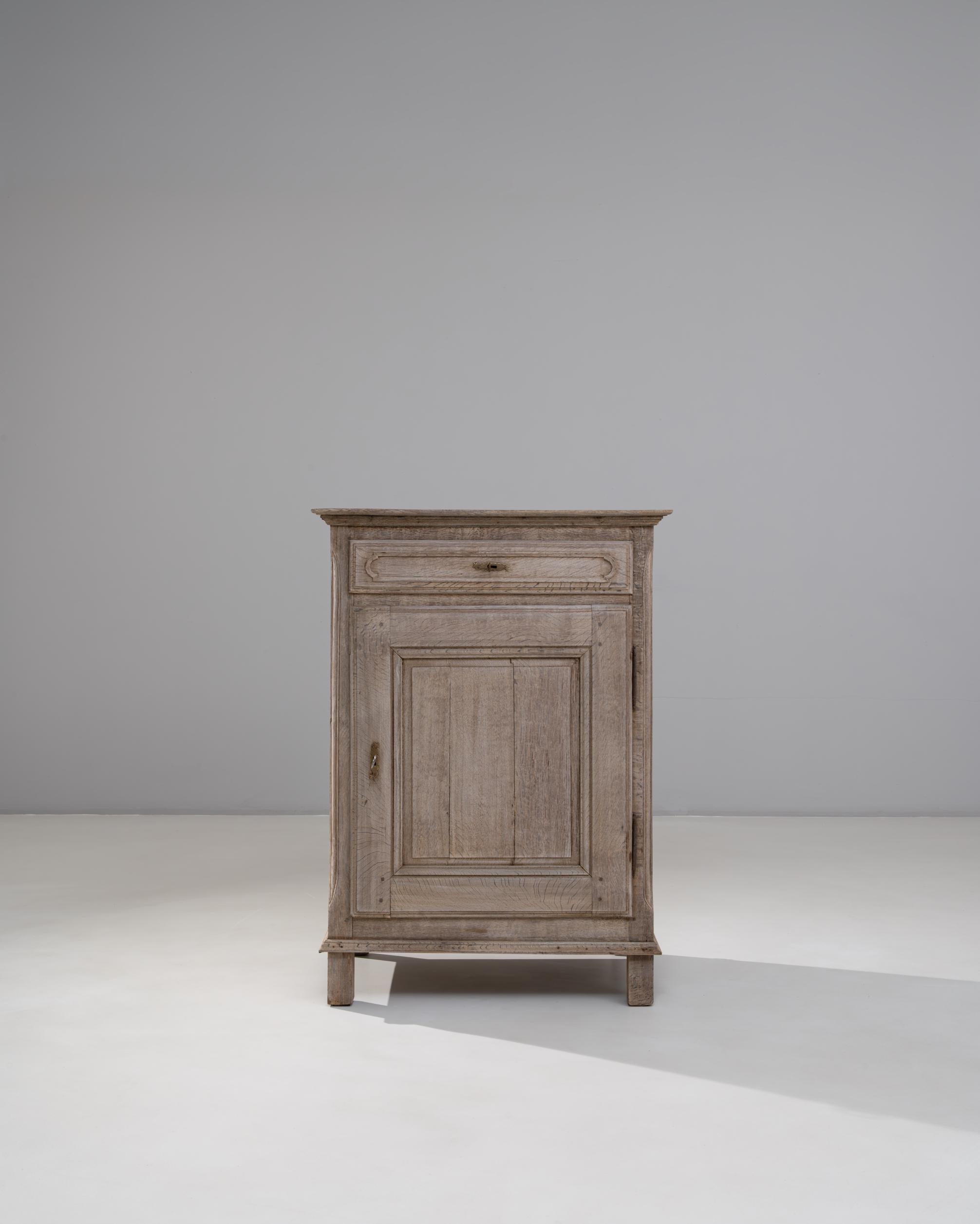 Questo buffet in rovere francese del 1900 con un'anta a pannelli è un classico esempio di sobrio artigianato di provincia, che offre autenticità e praticità. Realizzato in legno massiccio di quercia, il pezzo presenta una superficie splendidamente