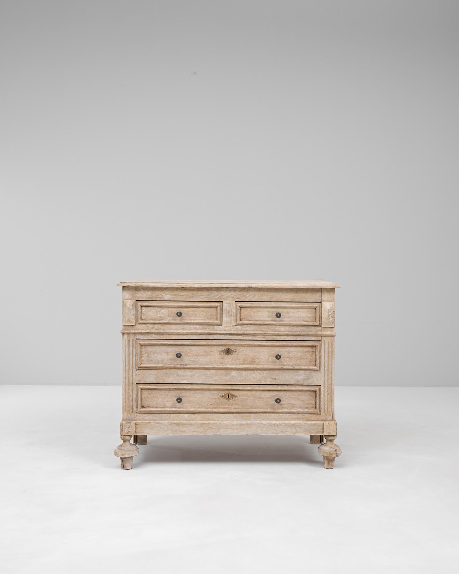 Questa cassettiera in legno di quercia francese del 1900 presenta una silhouette sobria ed equilibrata, basata sulla tradizione artigianale. La superficie in rovere sbiancato rivela una patina morbida e uniforme che mette in risalto le venature