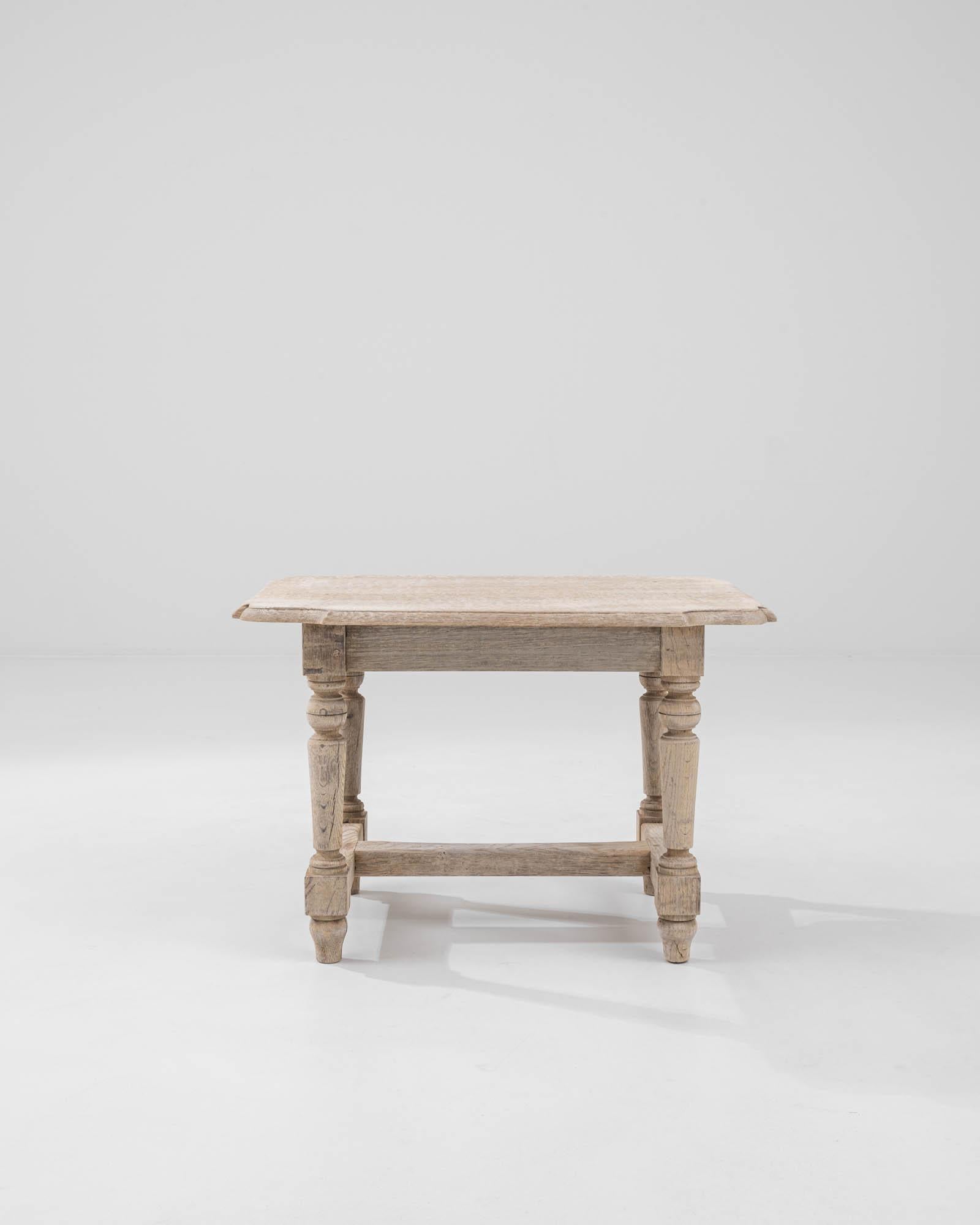 A wooden coffee table created in 1900s France. With elegantly joined stretchers, a tastefully sculpted top, and expertly lathed legs, this sturdy coffee table imparts a classic sense of farmhouse charm. The oak has been delicately treated with a