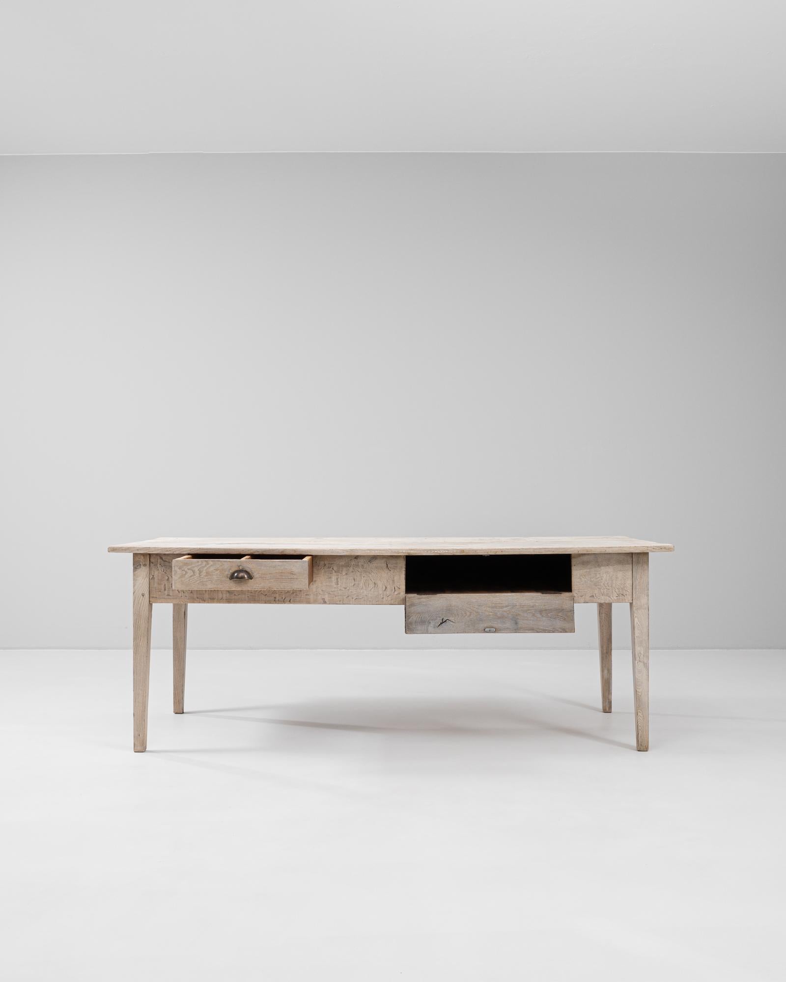 Fabricada a principios del siglo XX, esta mesa de comedor de roble francés desprende un encanto intemporal y una elegancia discreta. Su pátina naturalmente desgastada muestra la belleza del roble envejecido, resaltando la veta y el carácter únicos