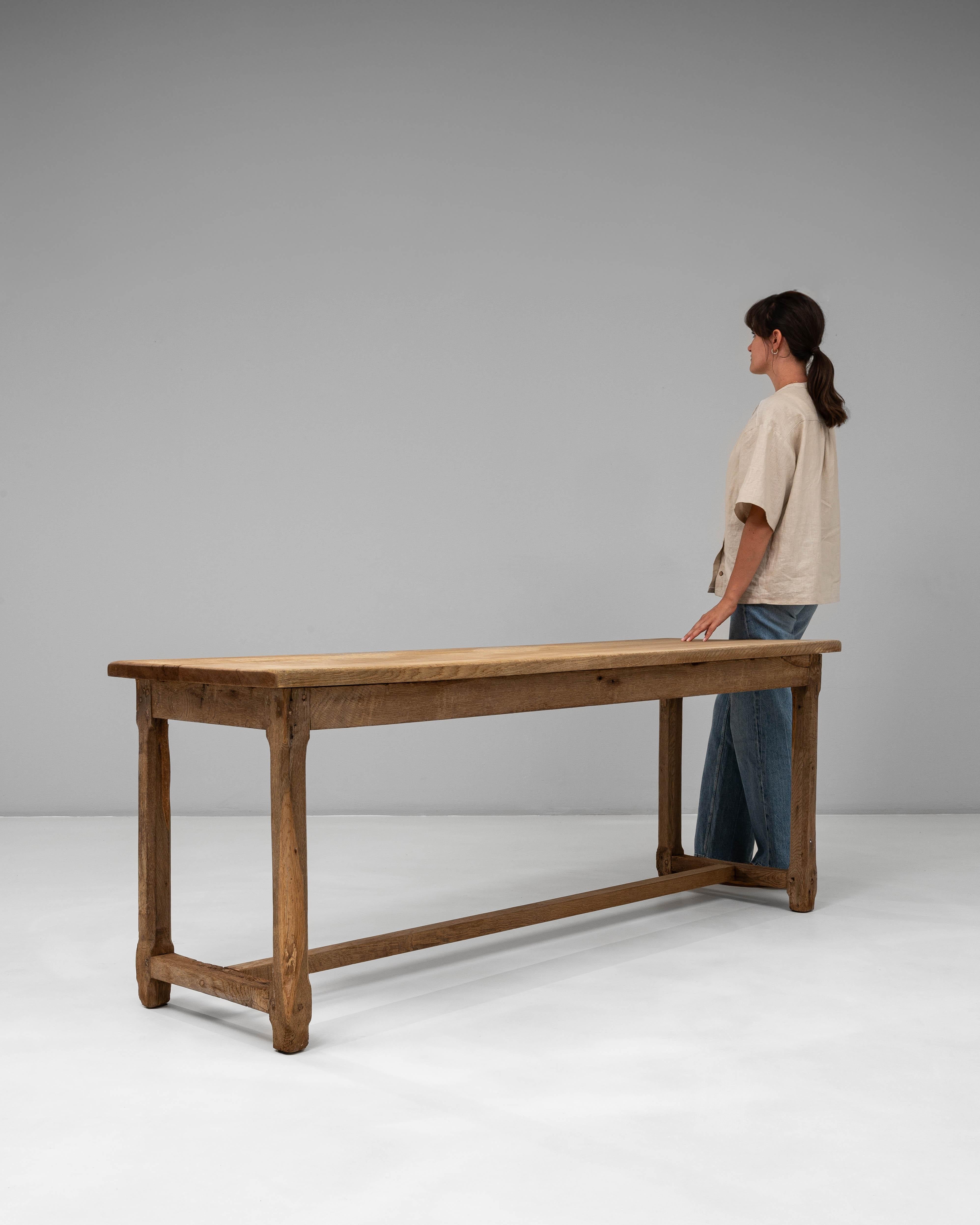 Cette table de salle à manger en chêne français des années 1900 présente un design magnifiquement discret qui met en valeur le caractère naturel et l'intégrité de sa construction en bois massif. Le plateau rectangulaire présente une variation