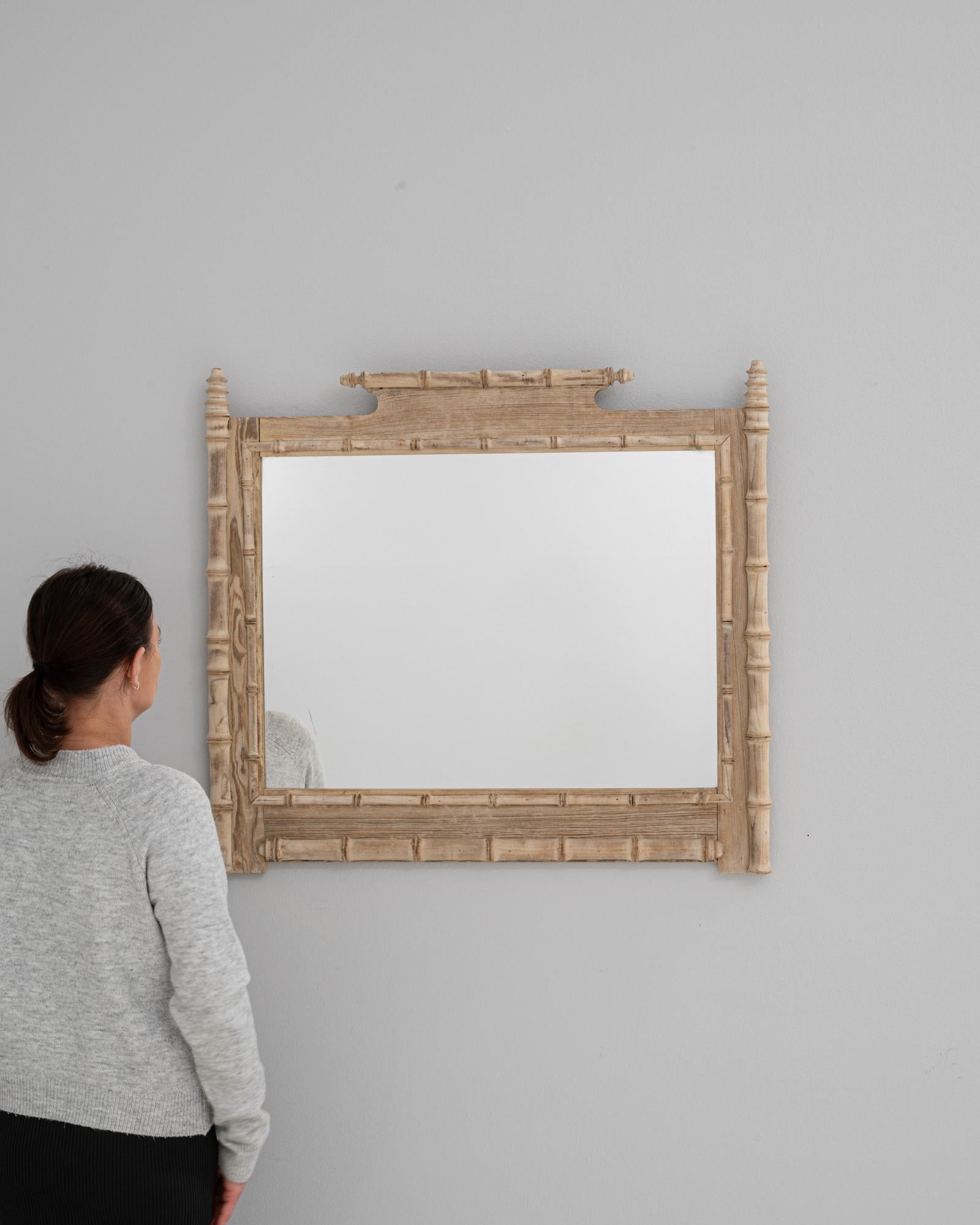 Questo specchio in legno di quercia francese del 1900 è un esempio sorprendente di artigianato in finto bambù, con una cornice rettangolare intagliata per assomigliare a steli di bambù, completa di dettagli di giunzione e finitura in legno naturale.