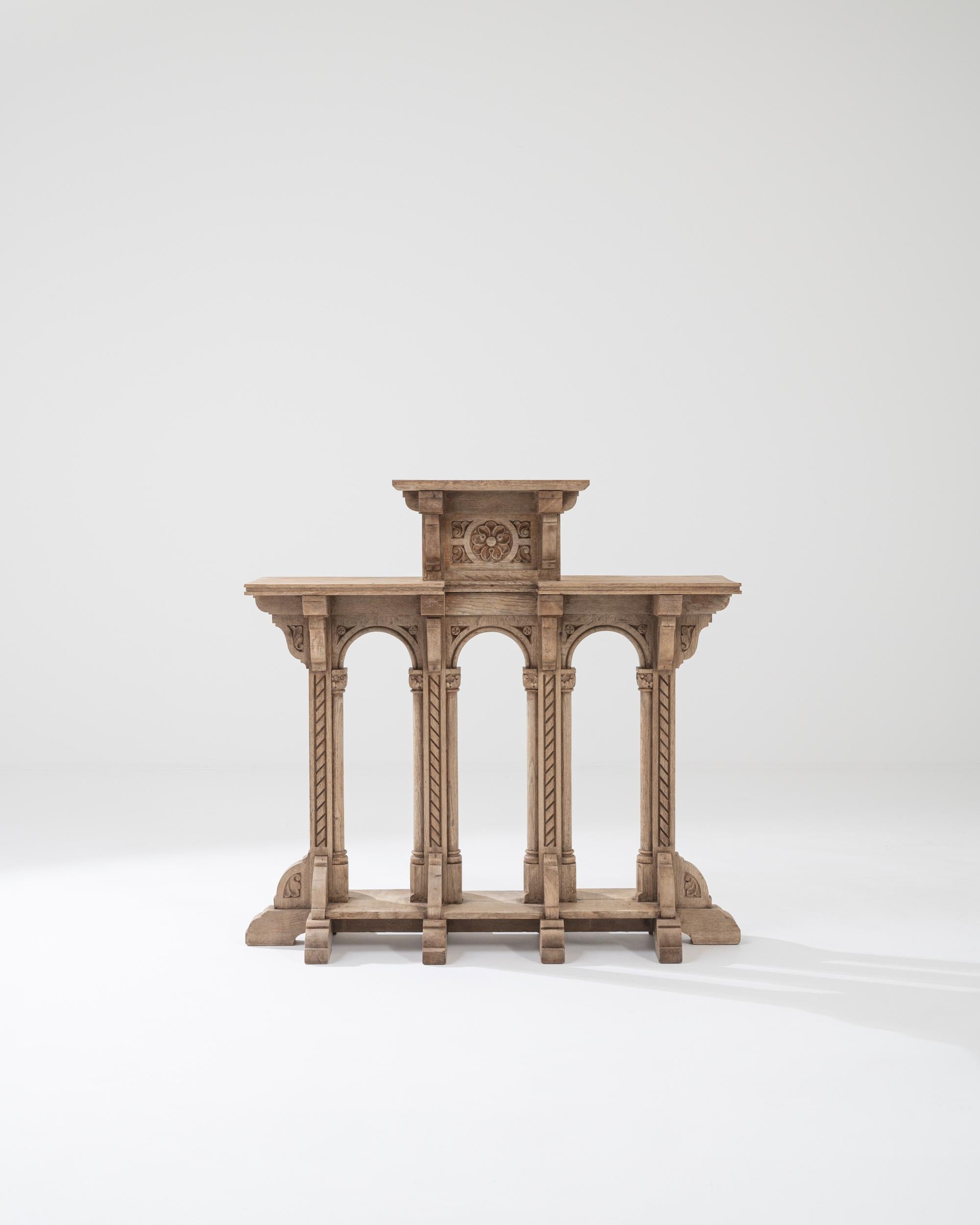 A turn of the century oak pedestal produced in France, this four columns pedestal makes for an ornate statement. Industriously hand carved, this corinthian inspired piece features three top shelves surfaces raised by molded corbel, rope twist