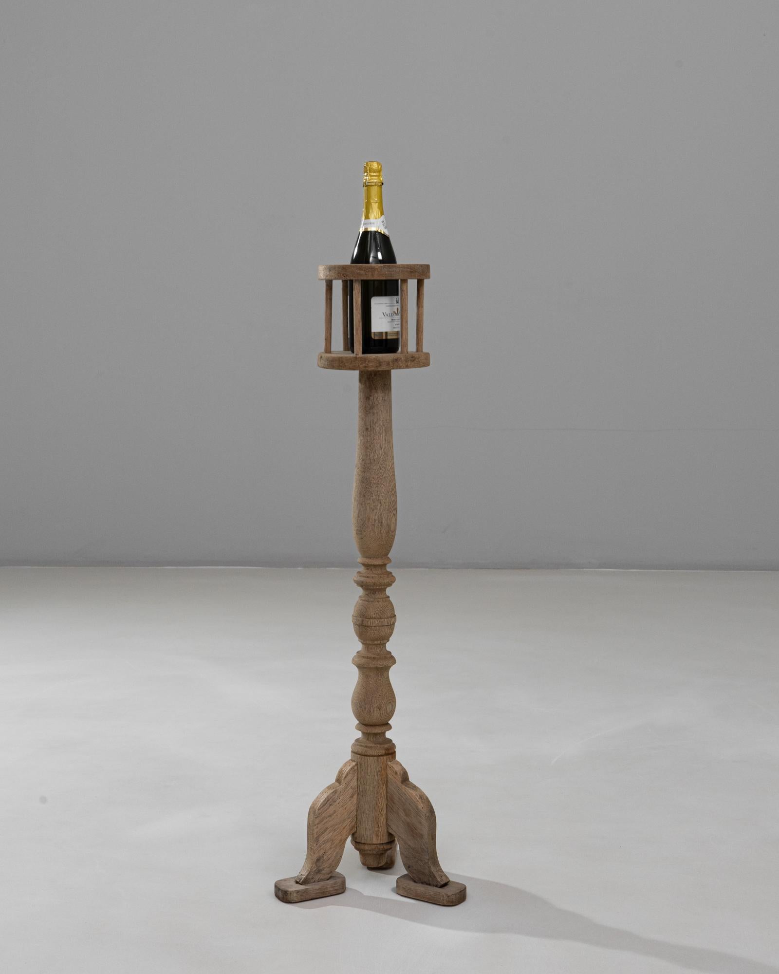 Questo piedistallo in quercia francese del 1900 è un pezzo d'accento elegante e versatile, con una colonna centrale finemente tornita e una base a treppiede con piedi delicatamente curvi. Il suo piano aperto a doghe era tradizionalmente progettato