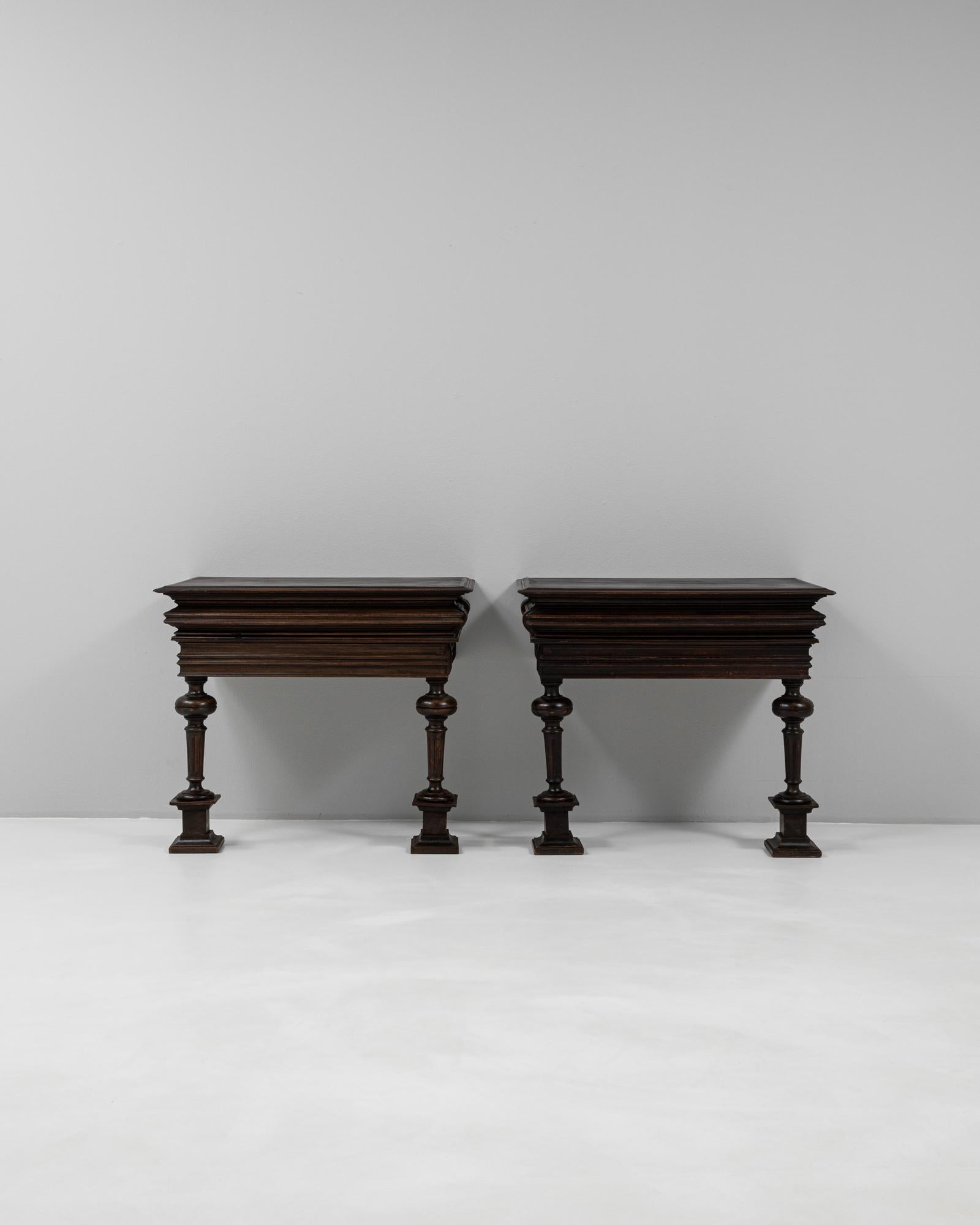 This pair of 1900s French console tables showcases exquisite craftsmanship and a rich, untouched patina that speaks to their age and authenticity. Constructed from solid wood, each table features a deeply molded top with stepped edges and