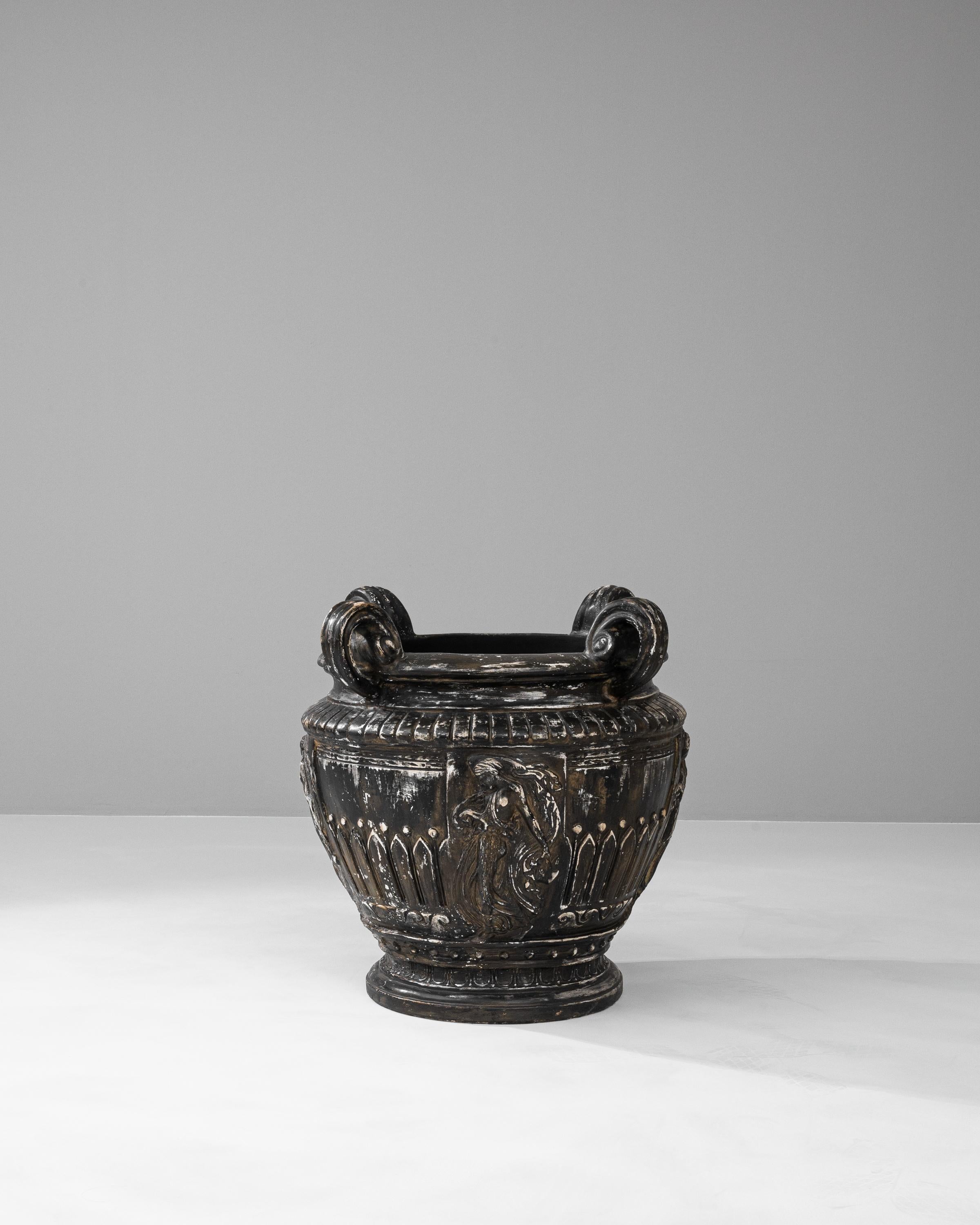 This 1900s French plaster vase is a remarkable relic, showcasing the grandeur and detail of neoclassical design. With its sweeping curves, ornate acanthus leaf motifs, and majestic volute handles, it carries the air of an archaeological treasure.