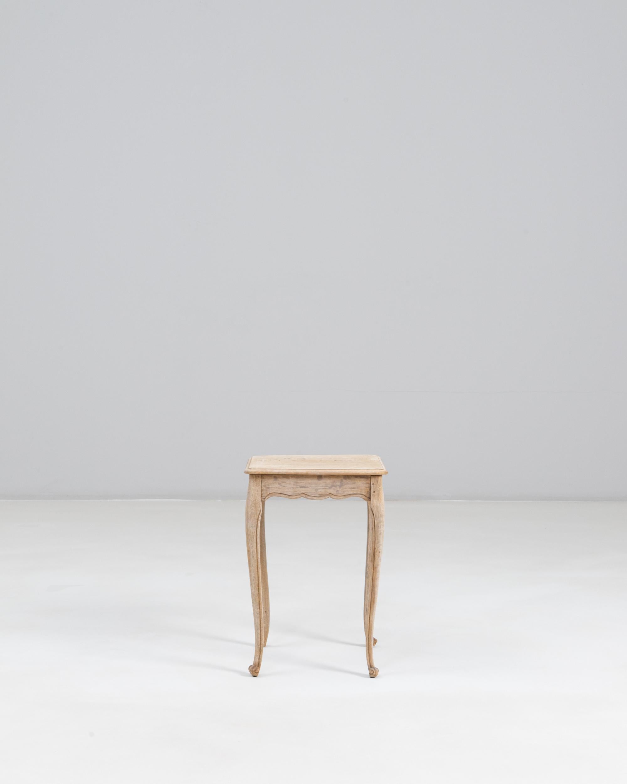 Table d'appoint en chêne de style provincial français des années 1900. Cette charmante table d'appoint reflète l'élégance discrète du Design/One. Elle est fabriquée en chêne avec une finition pâle et légèrement vieillie qui met en valeur le grain
