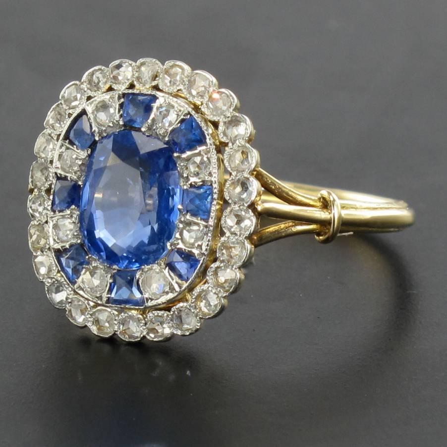 Ring in 18 karats yellow gold, owl hallmark and platinium, mascraon hallmark.
This beautiful antique ring is set with a cushion-cut sapphire surmounted by a double entourage of rose cut diamonds and rose cut diamonds and calibrated sapphires. The