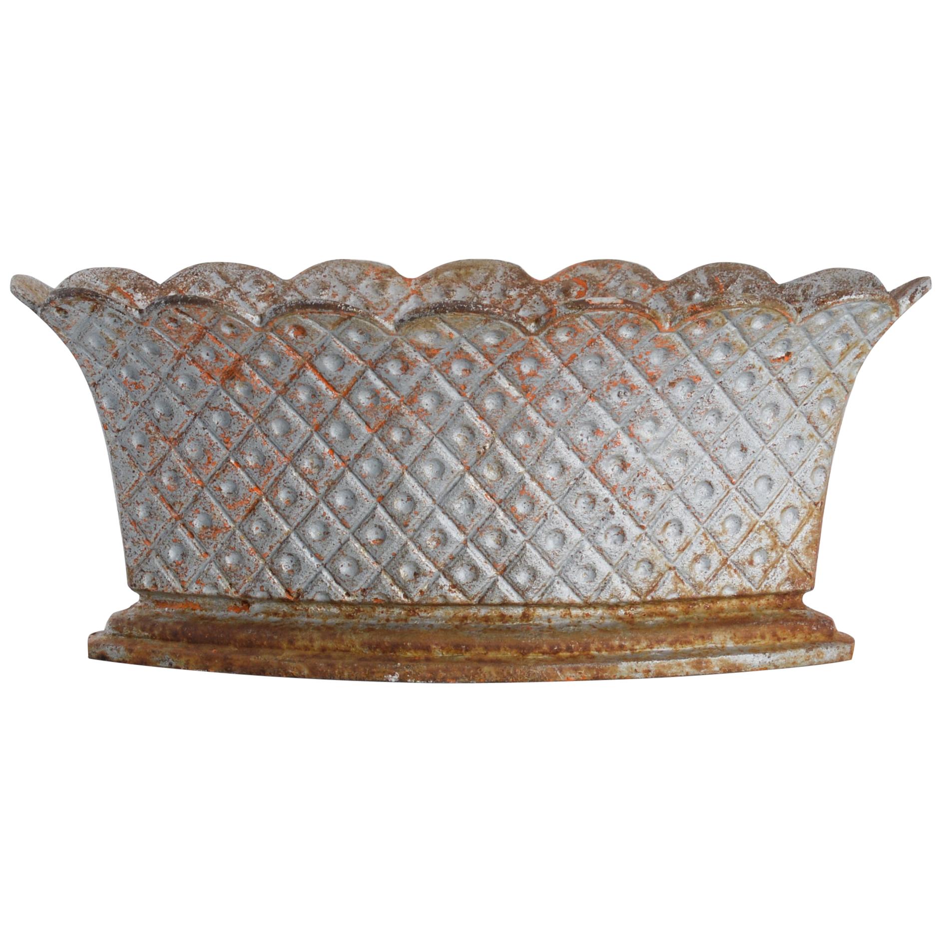 This cast iron planter with a stepped base was made in France, circa 1900. The diamond lattice pattern with circles and a scalloped rim give this planter a charming appearance. The planter has a lovely patina, which will bring character and a rustic