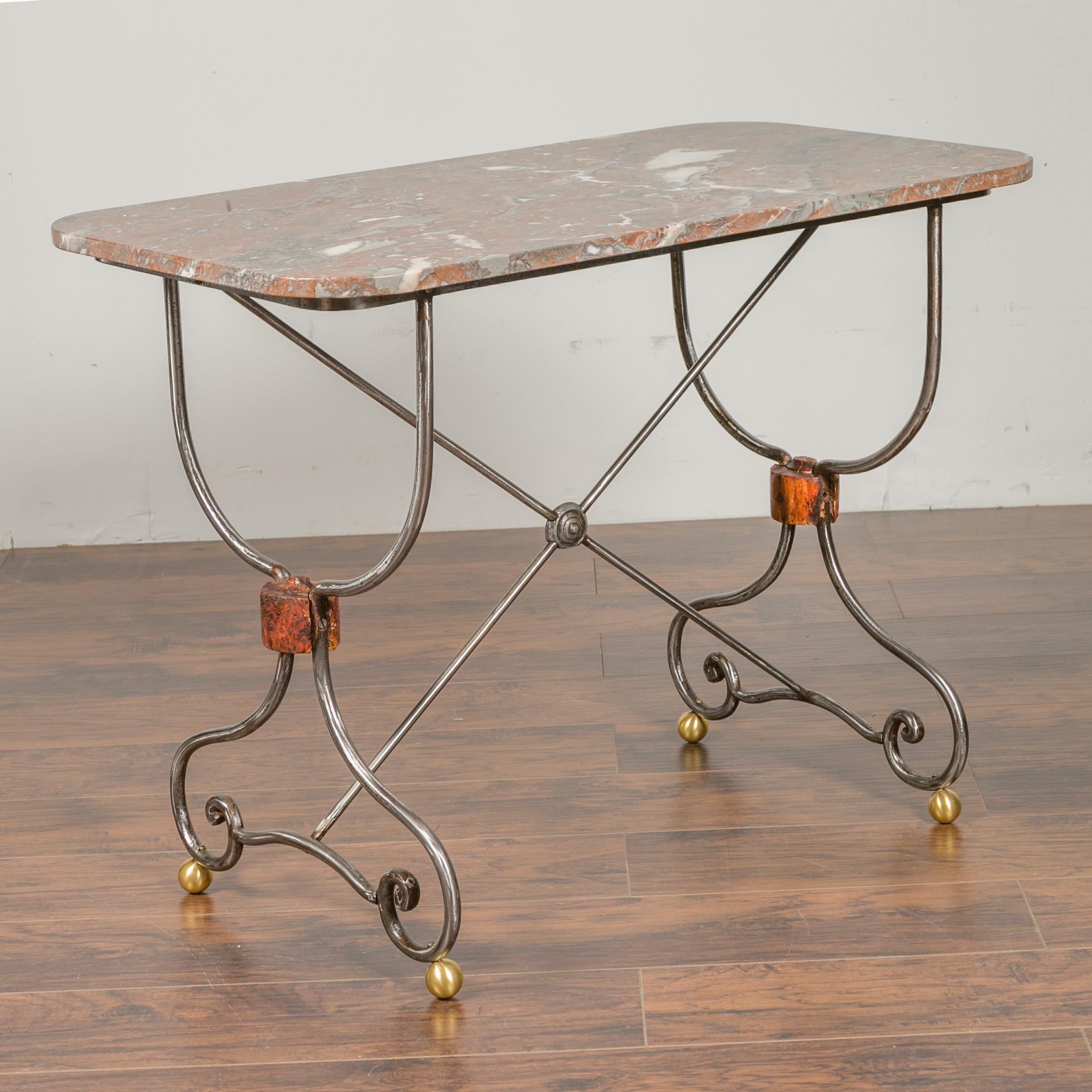A French steel and brass console table from the early 20th century, with variegated marble top and scrolling feet. We have a twin table available, see item LU836719327362 should you need a pair. They are priced and sold individually. Born in France