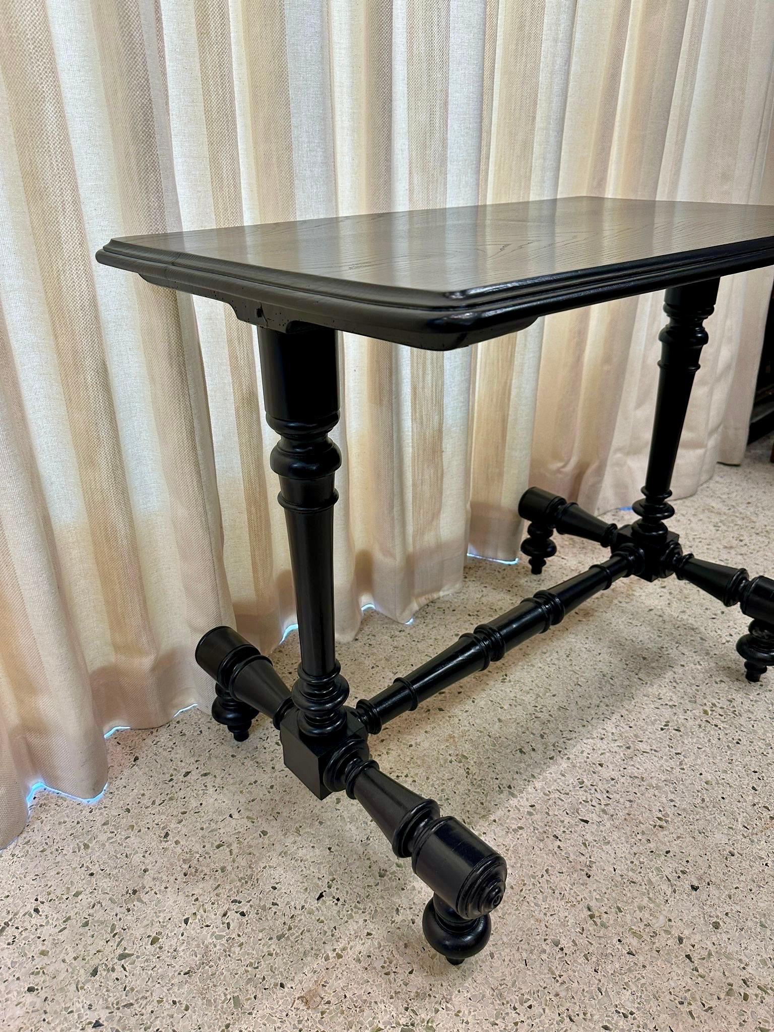 Récemment ébonisée, cette belle table en bois tourné présente des pieds et des traverses magnifiquement travaillés à la main.  La finition ébonisée a été réalisée récemment à des fins de restauration.
