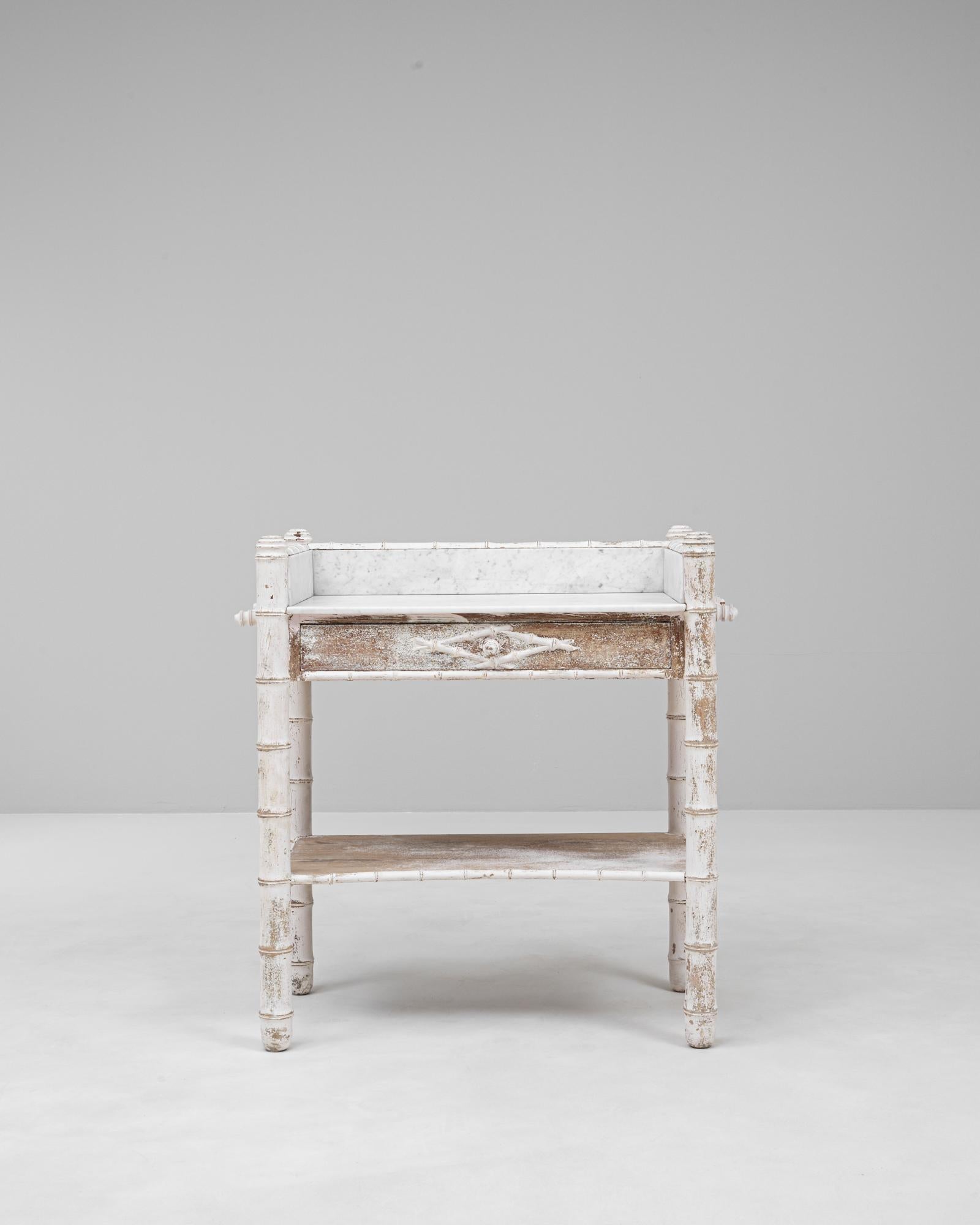 Questo tavolino francese del 1900 con piano in finto marmo di bambù patinato bianco cattura magnificamente il fascino e la leggerezza degli arredi decorativi della fine del XIX e dell'inizio del XX secolo. La struttura, realizzata imitando il bambù,