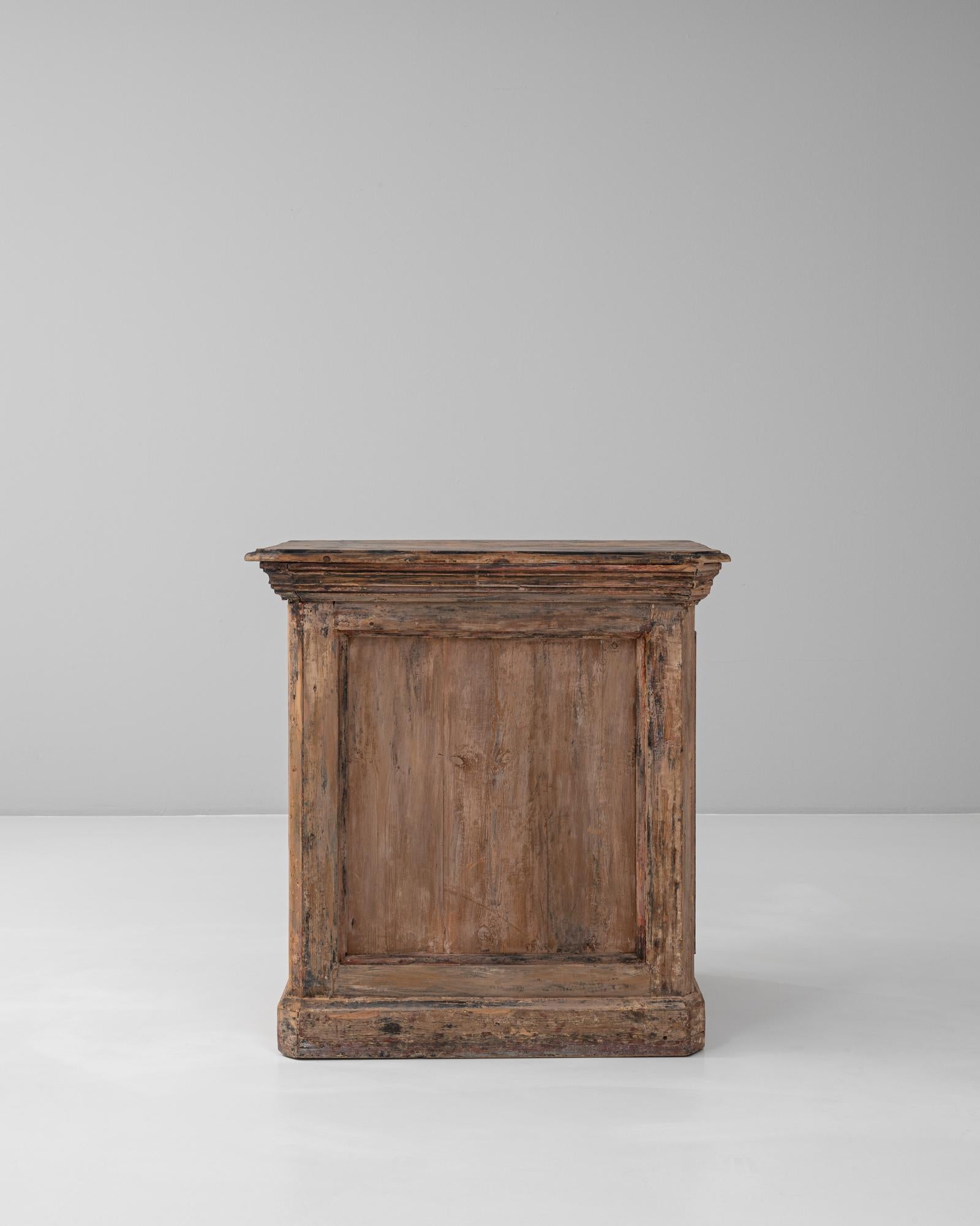 Questo bar francese del 1900 in legno patinato emana un carattere rustico e un fascino senza tempo. Realizzato in legno massiccio, il pezzo presenta strati di vernice originale e patina consumata dall'età, aggiungendo profondità e consistenza che ne