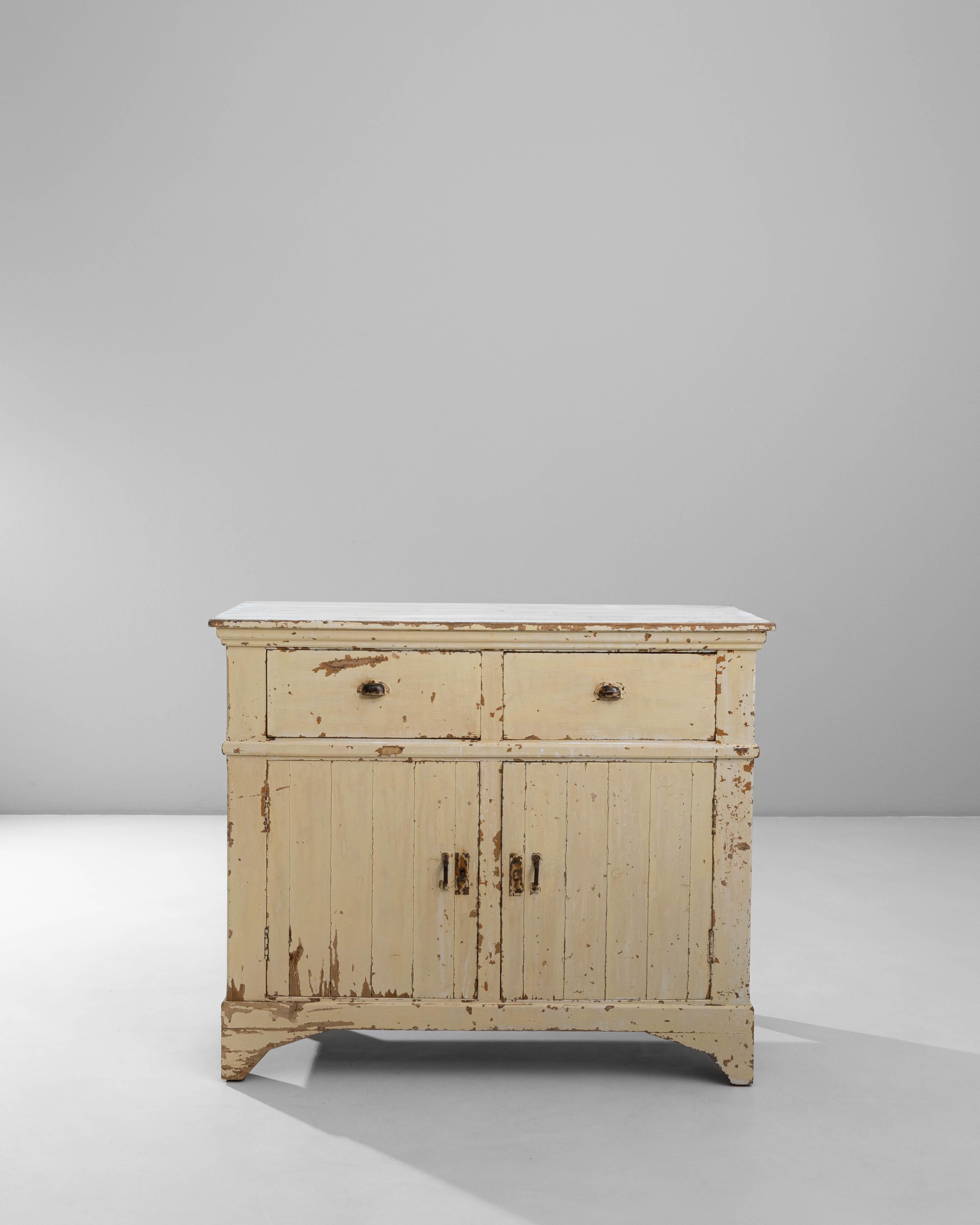 This 1900s French wood patinated buffet captures the charm of lived-in elegance with its original, timeworn finish and classic provincial silhouette. The creamy patina, worn beautifully across the surface, reveals layers of age and character that