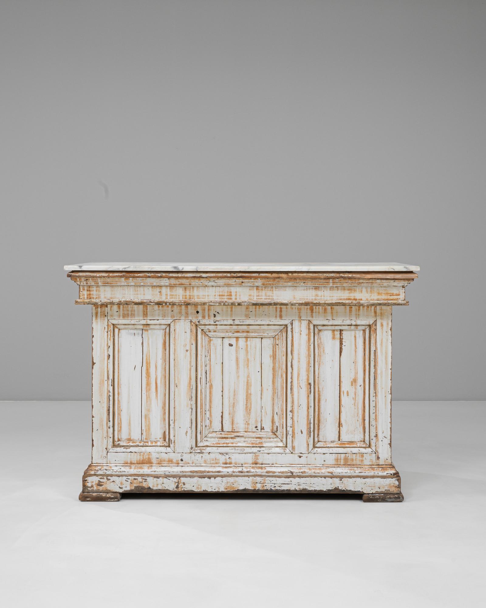 Questo bar francese del 1900 in legno bianco patinato con piano in marmo cattura il fascino rustico unito all'eleganza classica. La struttura in legno massiccio è rifinita con una patina bianca e distorta, che rivela strati di storia e carattere