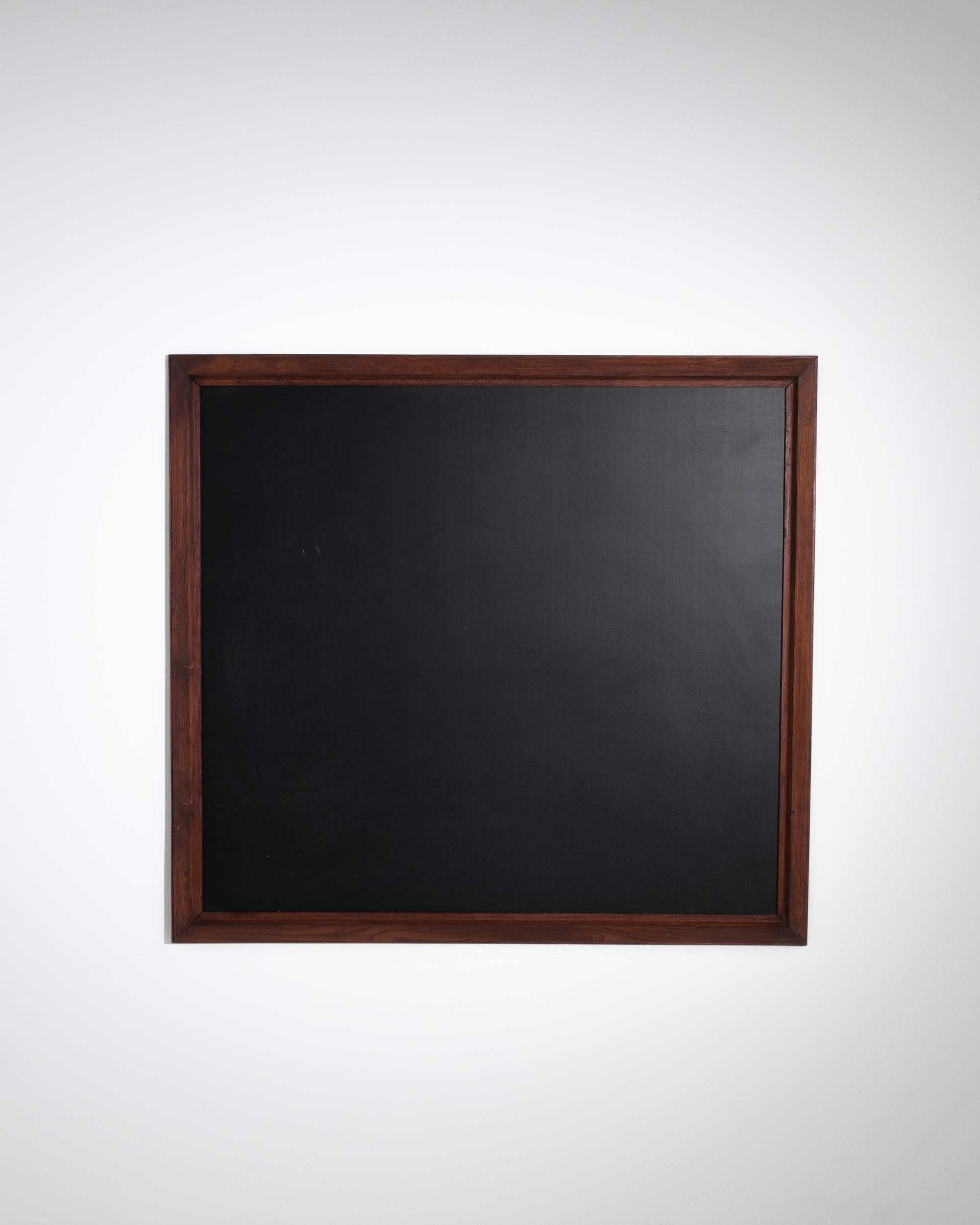 A wooden black board from France, produced circa 1900. Stretching four feet wide and standing nearly as tall, this scholastic rectangle will stir memories of childhood school days: soft whisper of deftly handled chalk carving yellow lessons into the