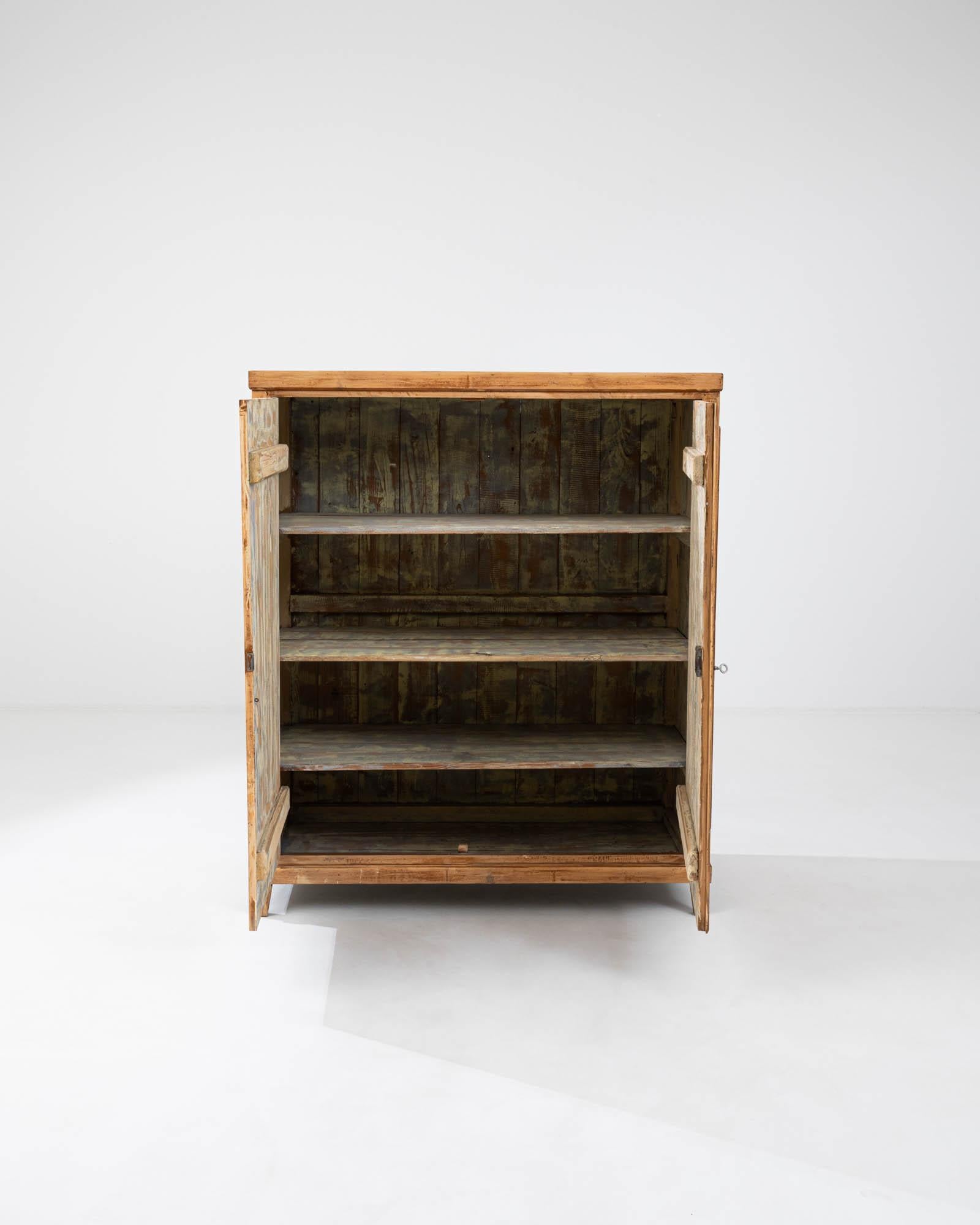 This early 1900s French Wooden Buffet is a testament to the timeless allure of natural wood and traditional craftsmanship. The buffet's robust silhouette, constructed from richly patinated pine, exudes a sense of rustic elegance and durability. Each